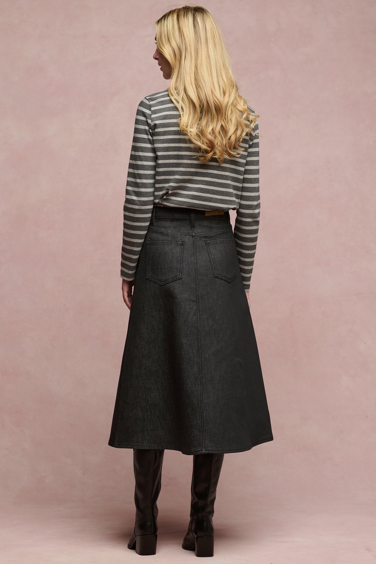 The back of female wearing Bobbie a line denim skirt in black paired with charcoal Breton and black boots