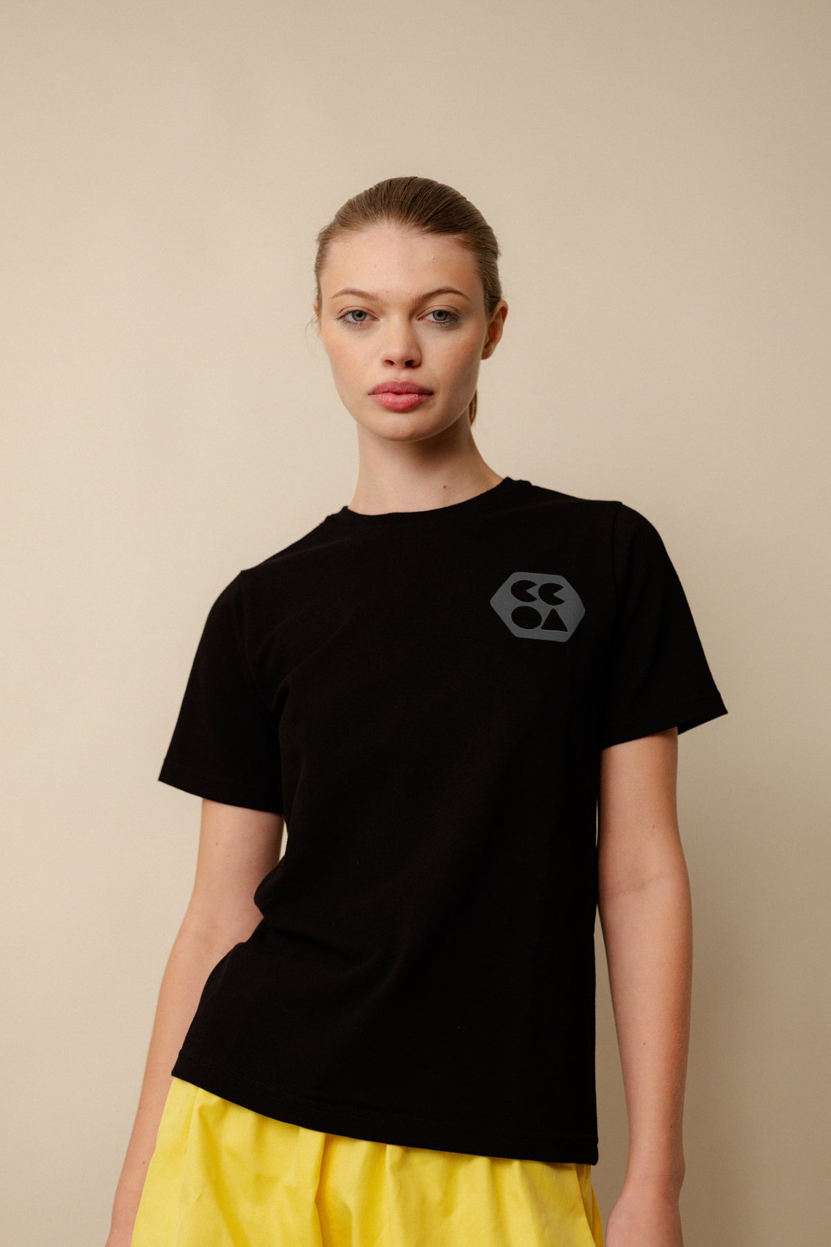 White female wearing breathable short sleeve t shirt in black with CCOA logo