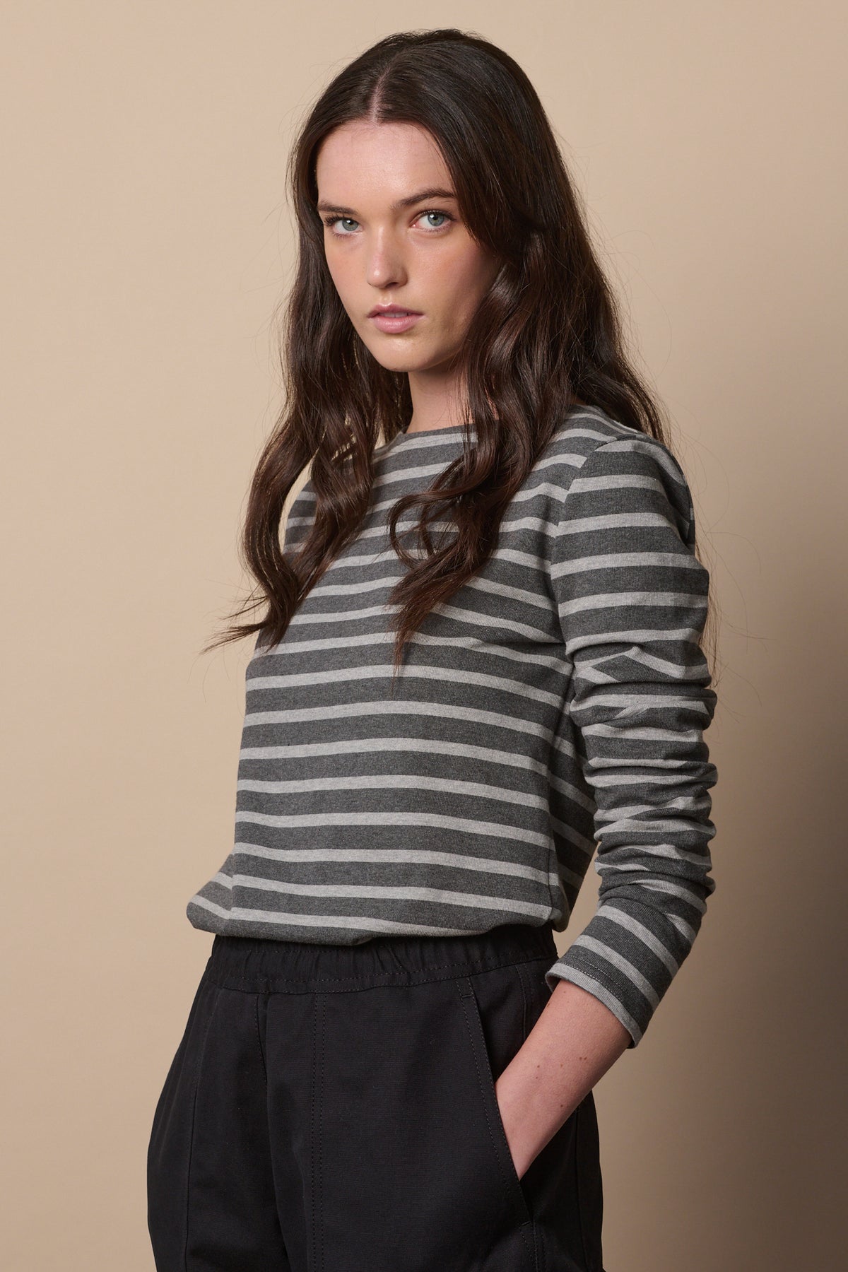 
            White female with long brunette hair wearing Breton in charcoal marl and grey marl tucked into trousers with sleeves pushed up the arm