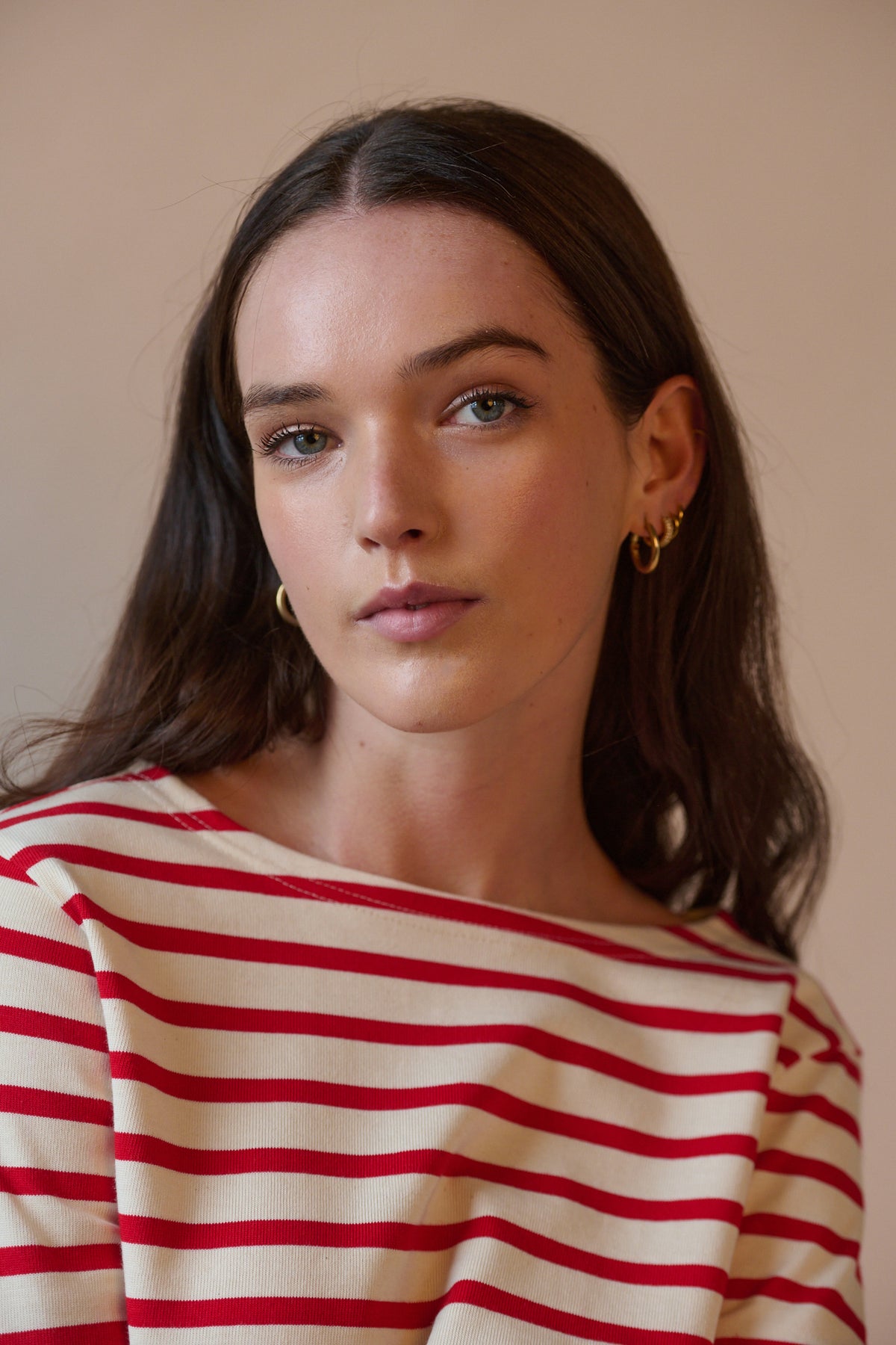 
            Portrait of white female with long brunette hair wearing Breton in ecru and red with boat neck