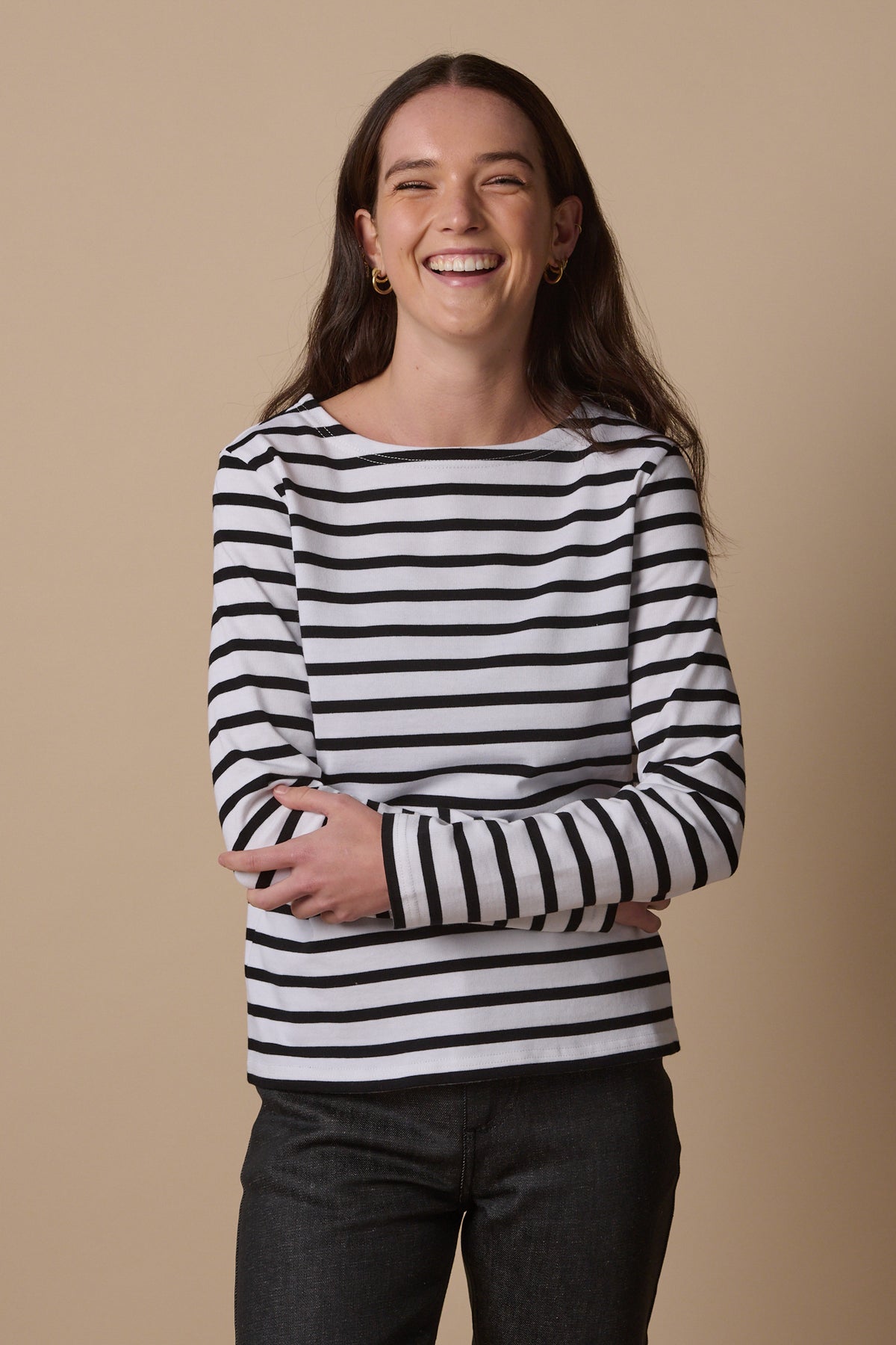 Thigh up image of smiley female wearing Breton in white and black