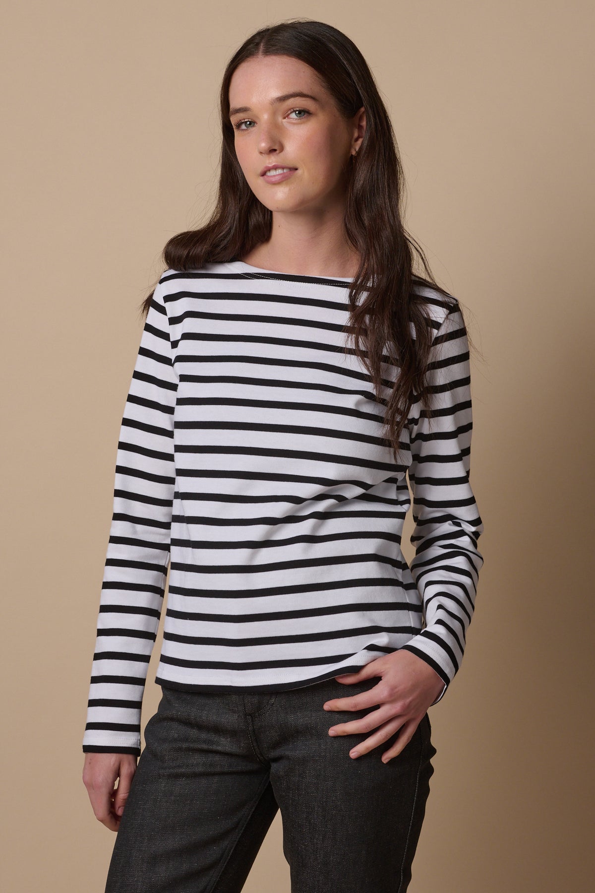 Thigh up image of female wearing long sleeve white and black Breton