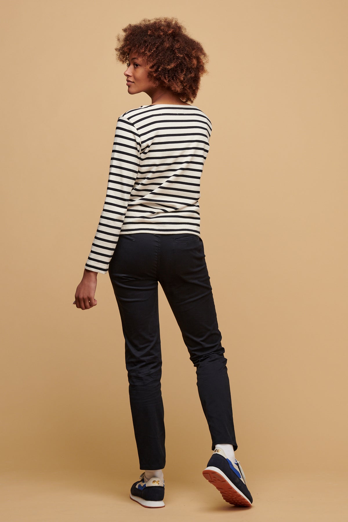 
            The back of female wearing slim stretch chino in navy paired with ecru/navy Breton 