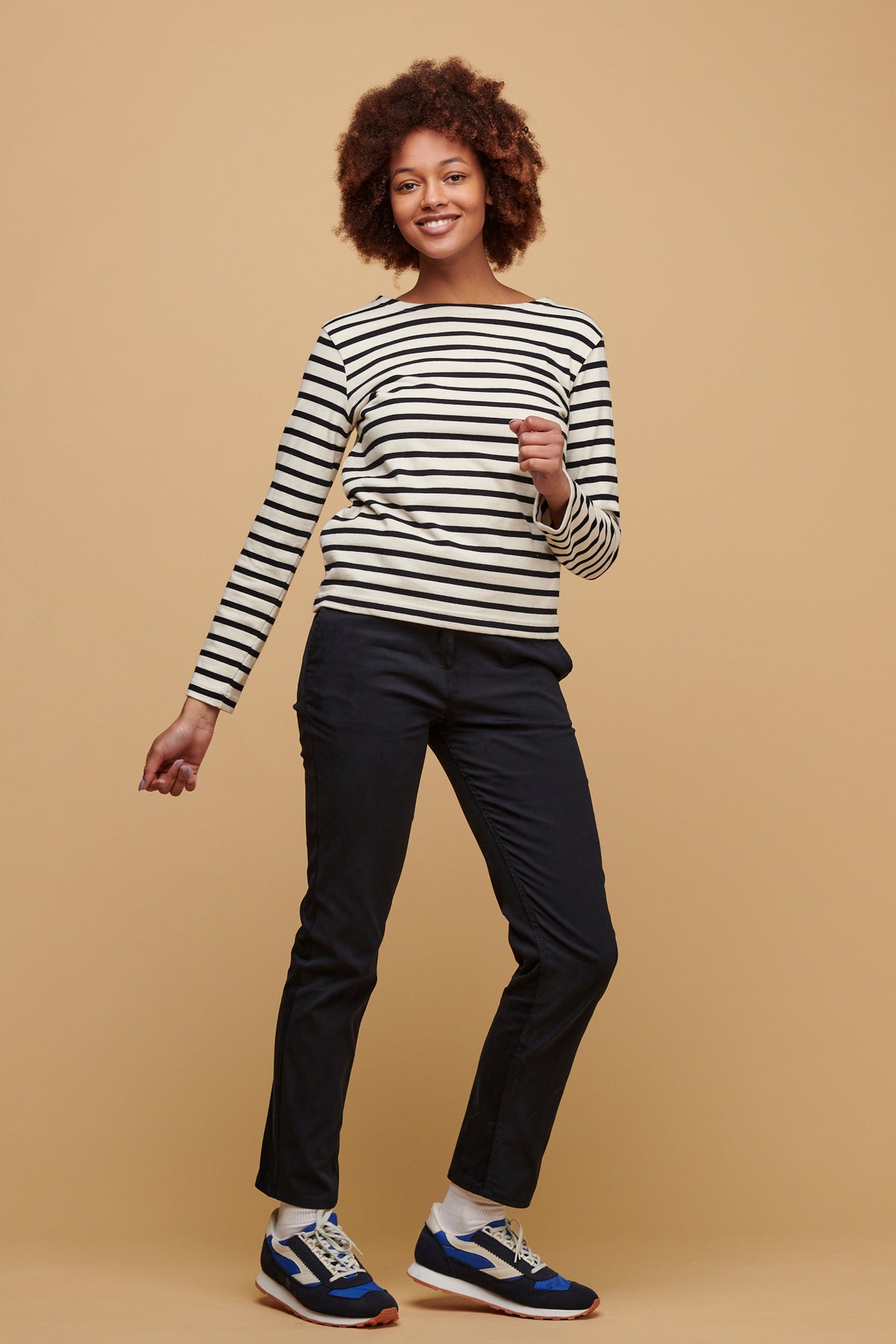 
            Smiley, black female with afro wearing women&#39;s slim stretch chino in navy paired with ecru navy stripe Breton