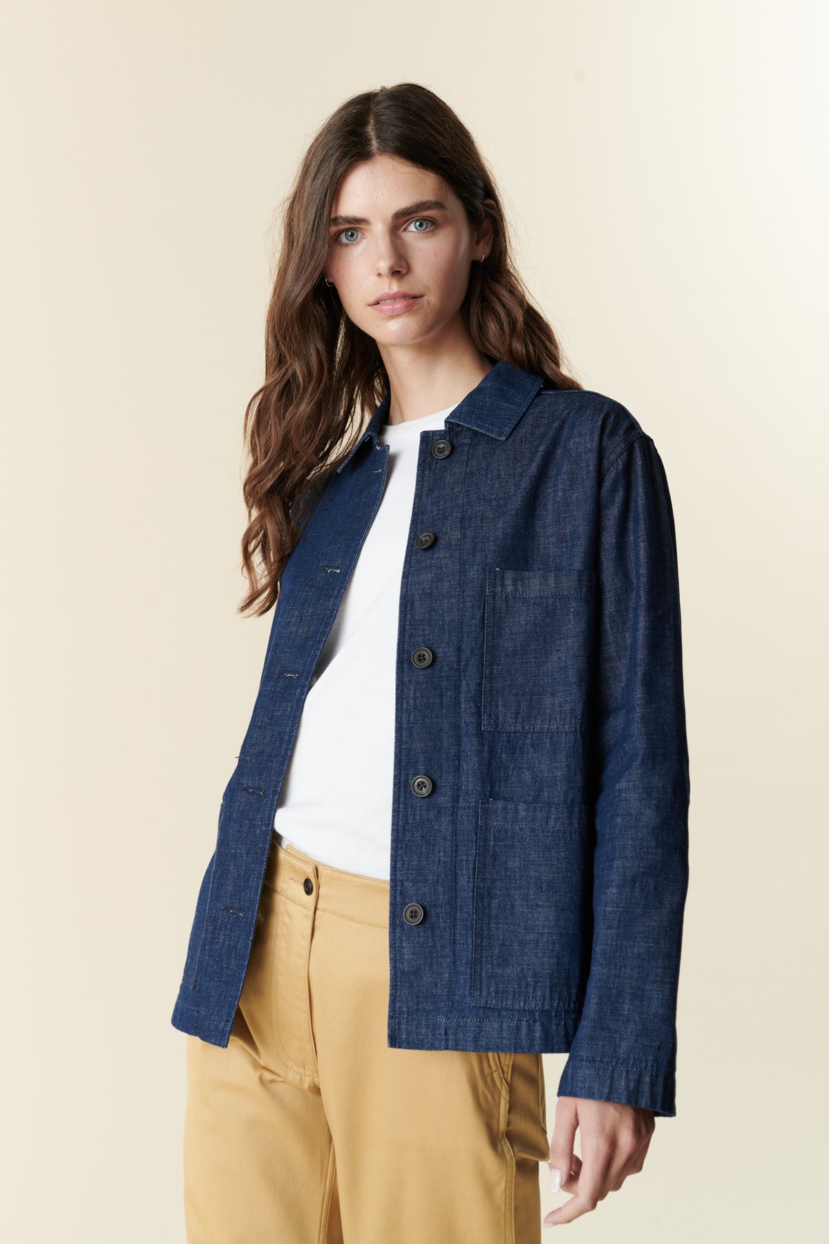 Front, thigh up image of brunette female wearing chore jacket in denim