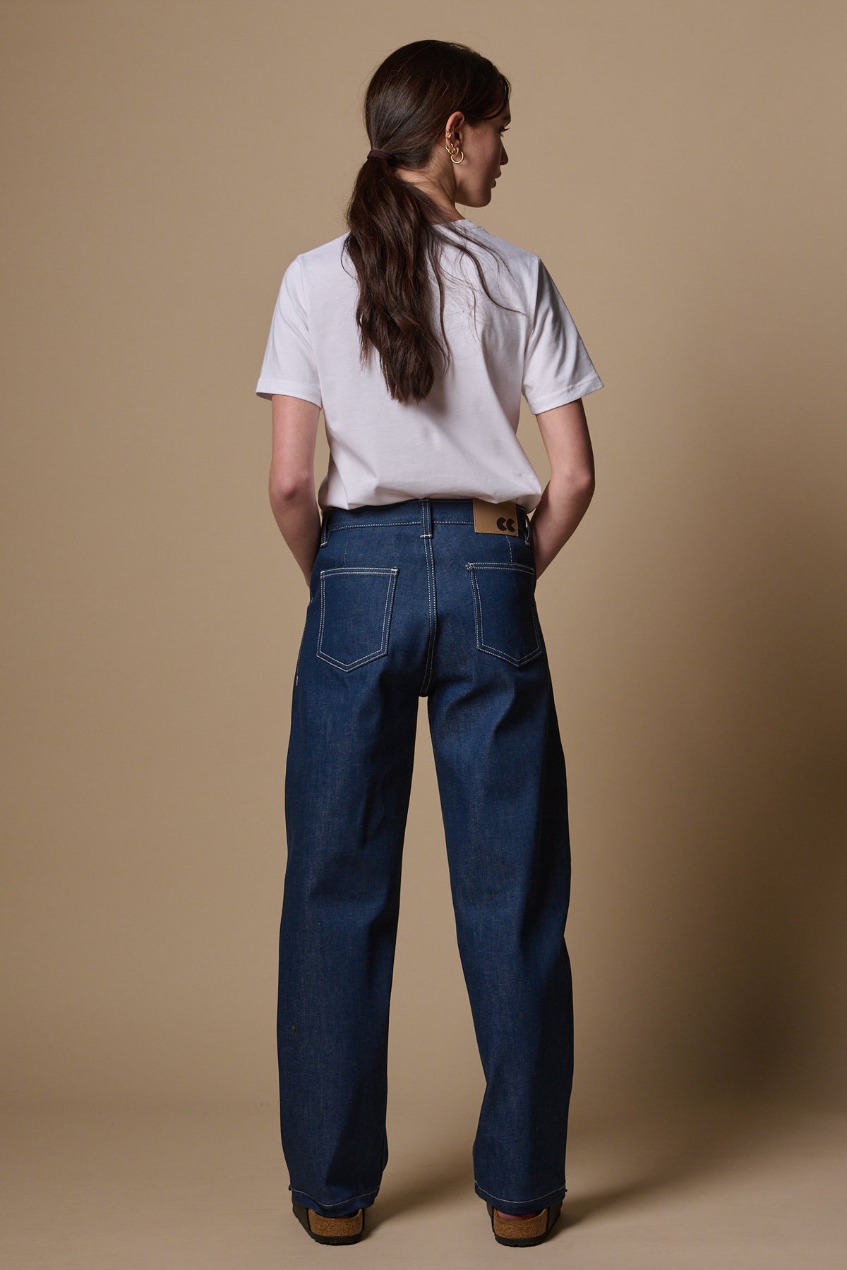 
            Full body image of the back of female wearing chore jeans in blue