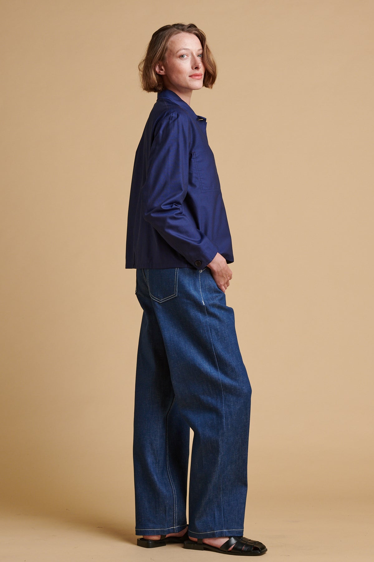Female wearing chore jeans in blue paired with Elena shirt in navy.