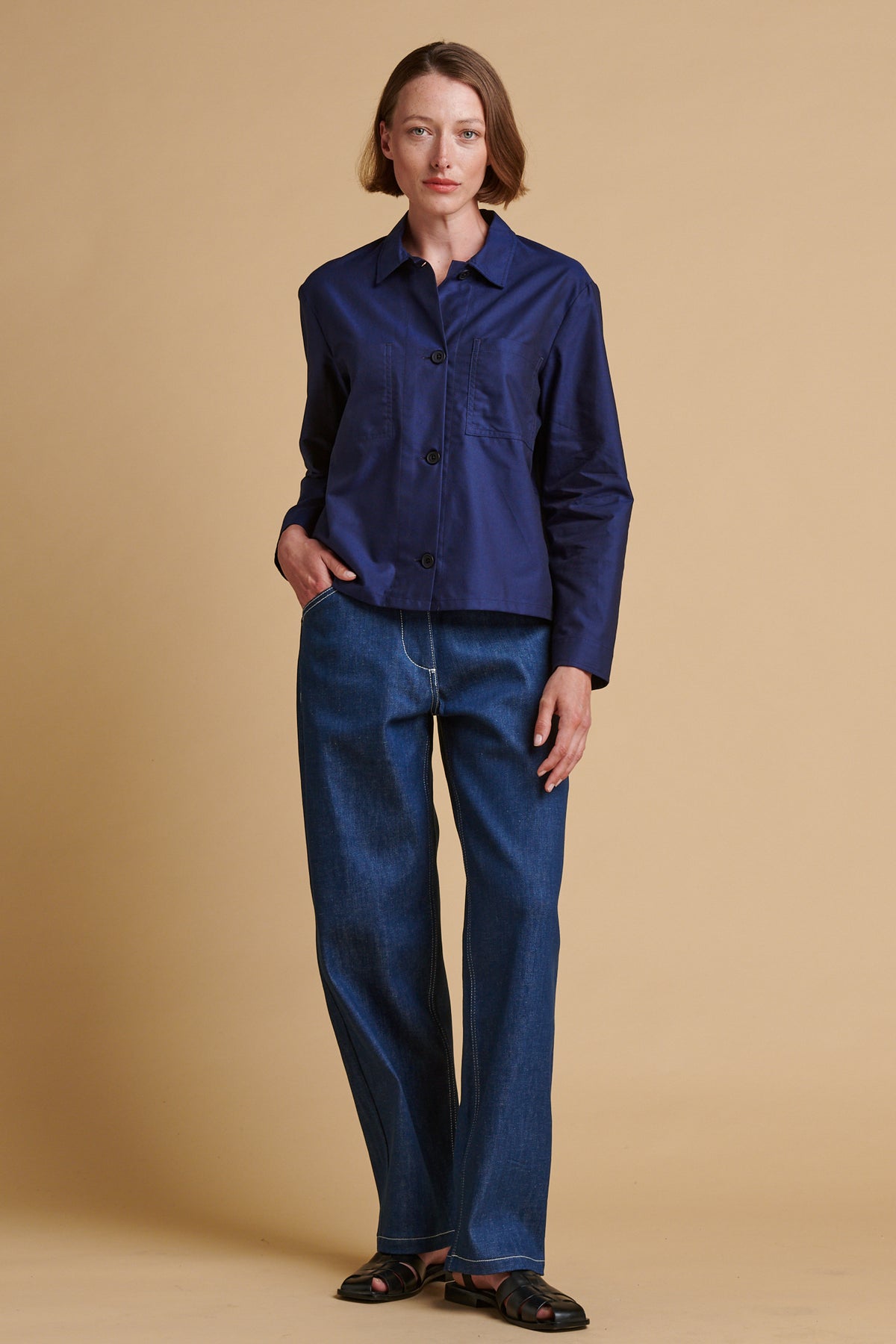 Female wearing chore jeans in blue paired with Elena shirt in navy.