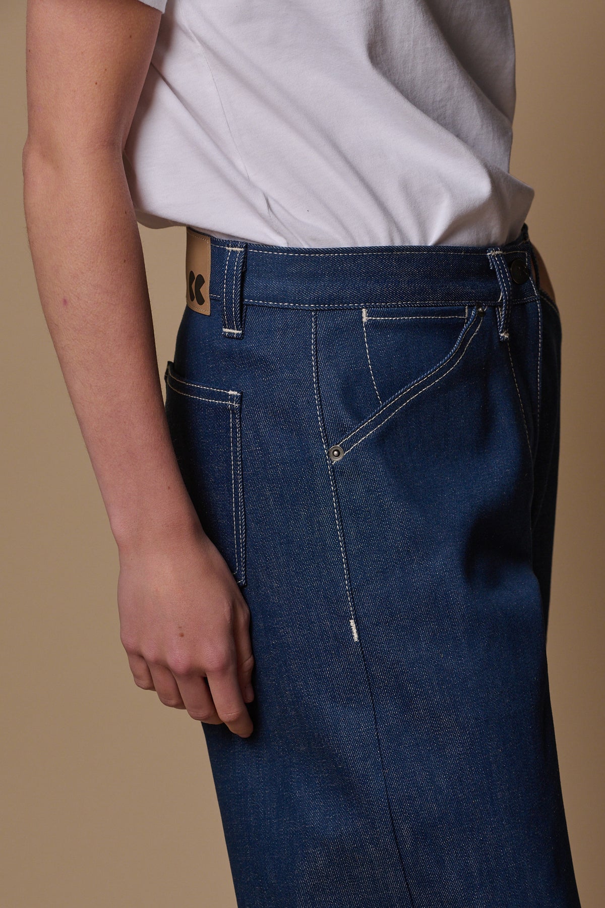 
            close up of side of chore jeans showing coin pocket an rivets, contrast white stitching.