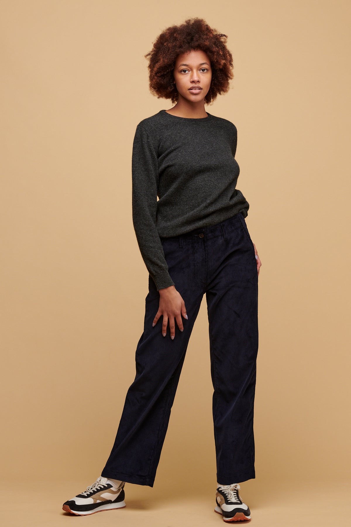 Female wearing women's corduroy work trousers in navy paired with lambswool crew neck in charcoal.