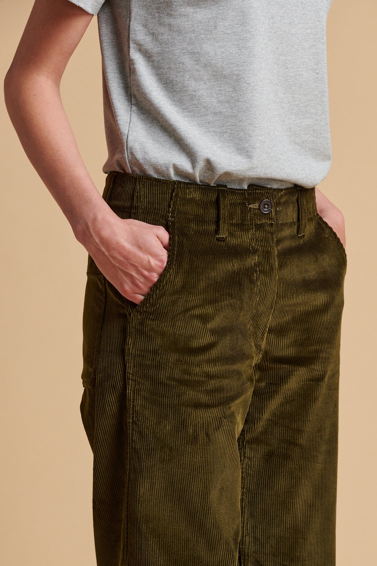 Close up of the waistband of corduroy work trousers in olive.