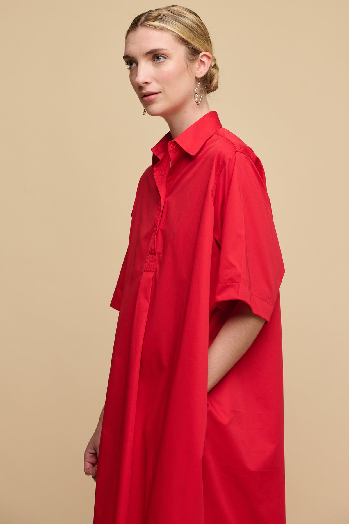 Thigh up image of cotton dress in red without belt tie for a looser fit.