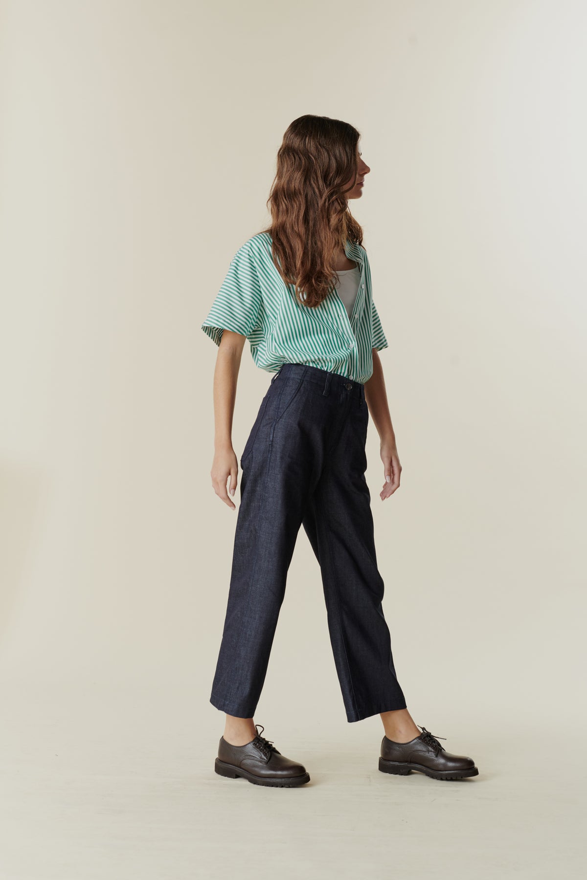 
            Side view of female wearing cropped work trousers in denim 