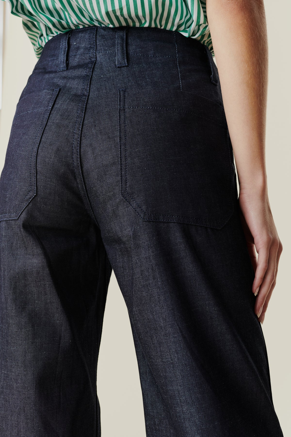 
            back pocket and belt loop detail of cropped work trousers on female model