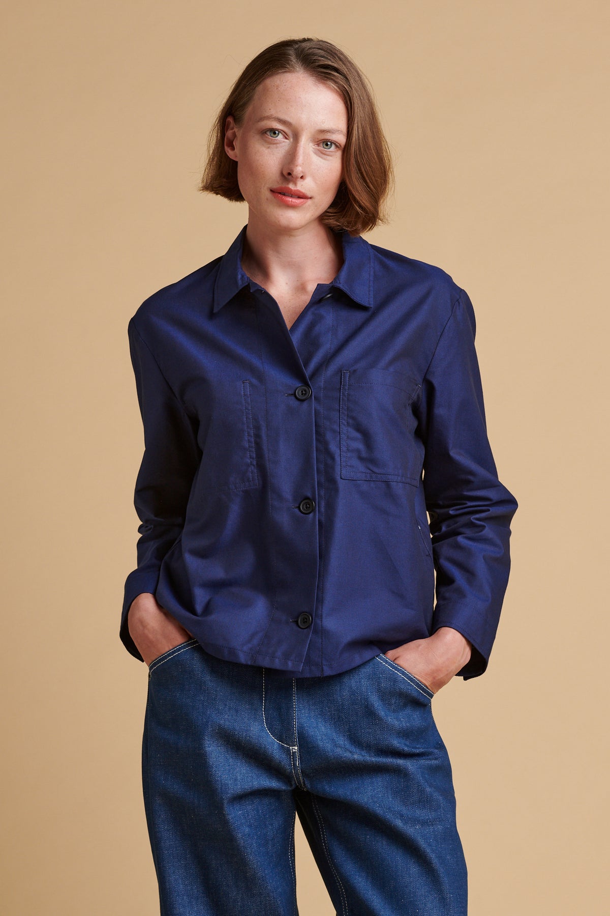 Thigh up front of female wearing Elena shirt in navy.