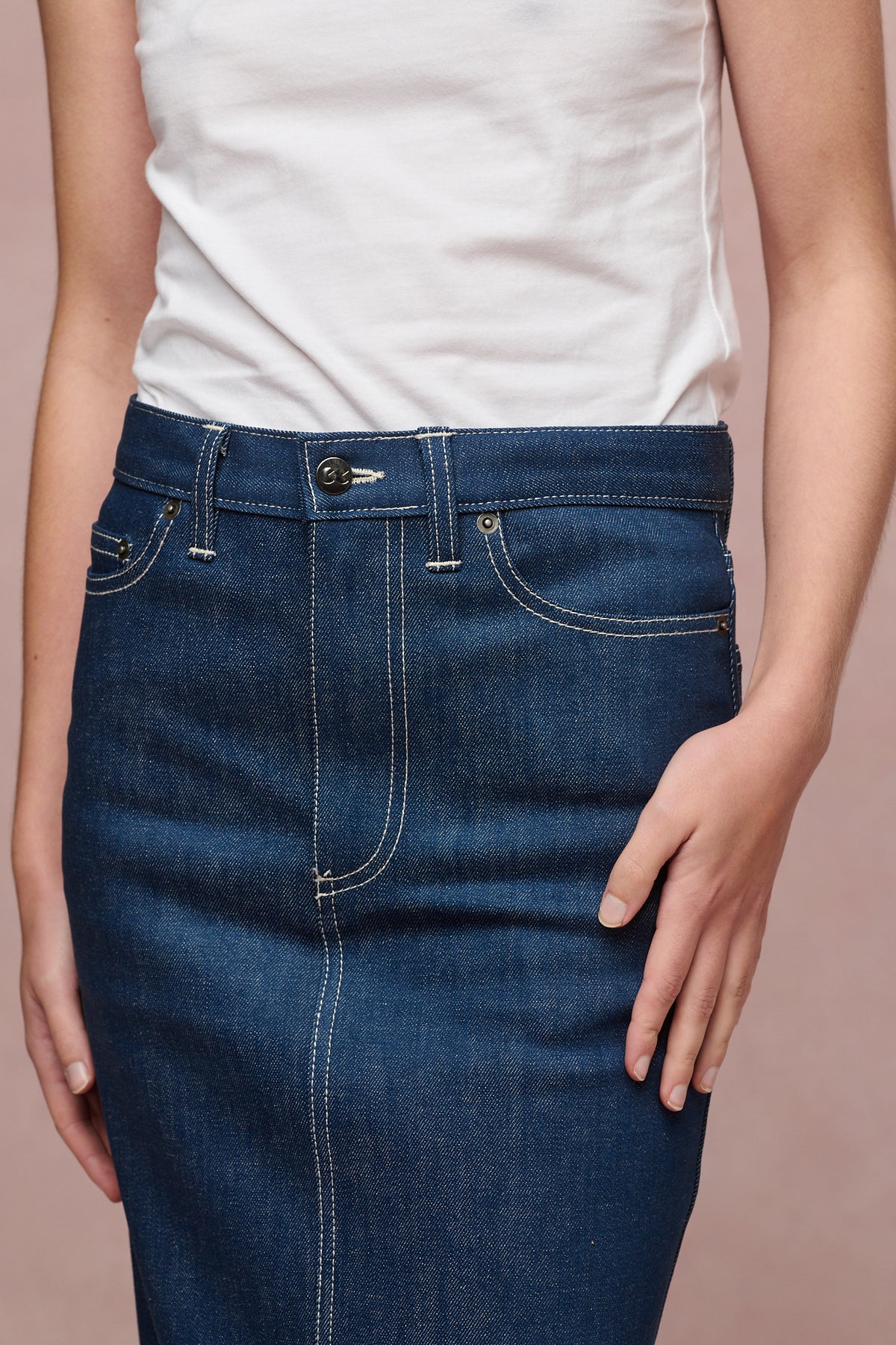 Close up of the front of Frankie denim maxi skirt in blue with two front pockets and coin pocket, zip fly and belt loops