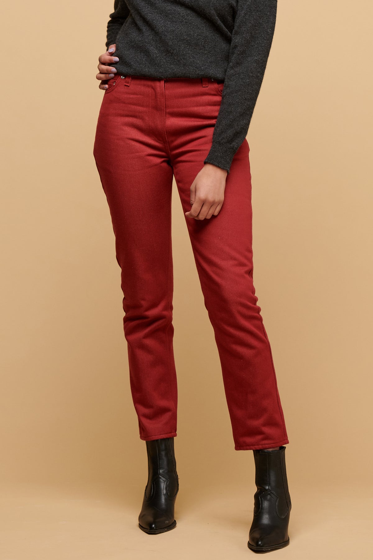 Chest down of female with hand on hip wearing Gloria jean in burgundy paired with black boot