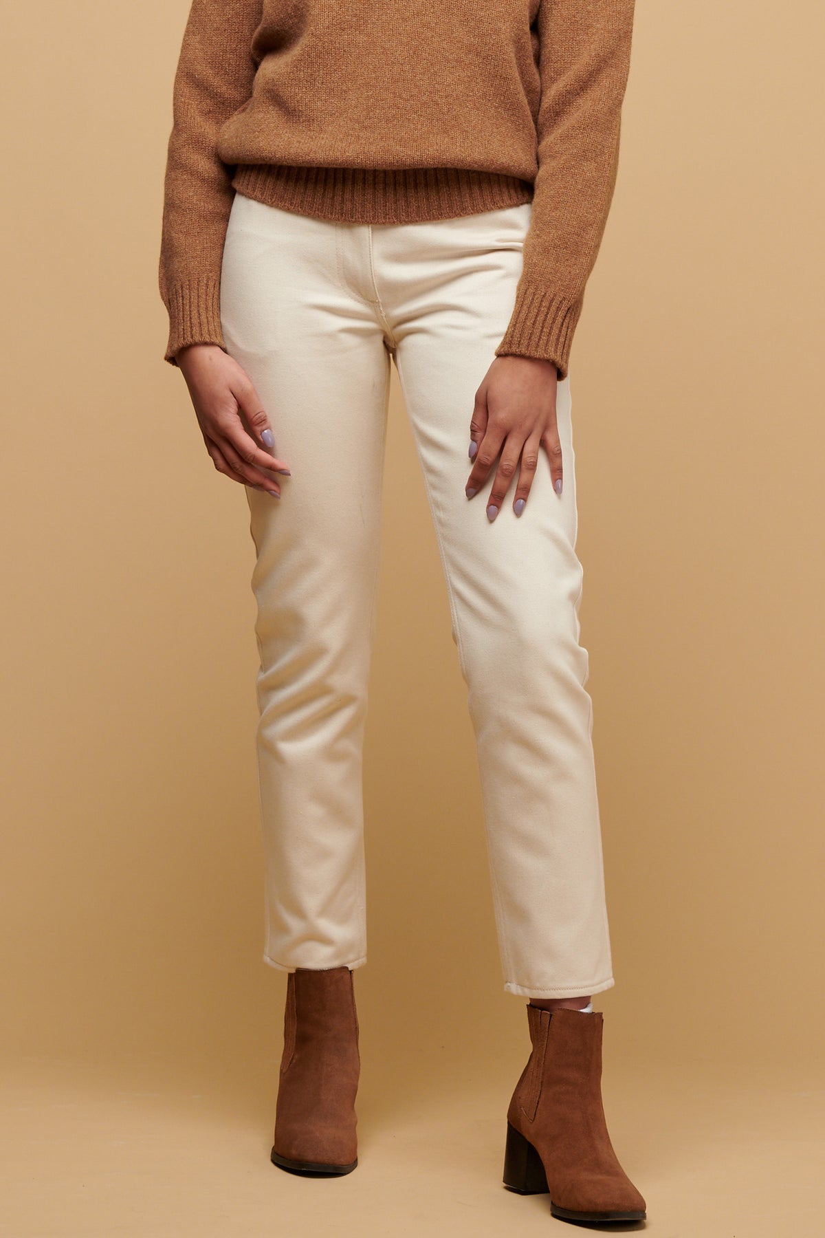 Chest down of female wearing Gloria jean in ecru paired with suede boots
