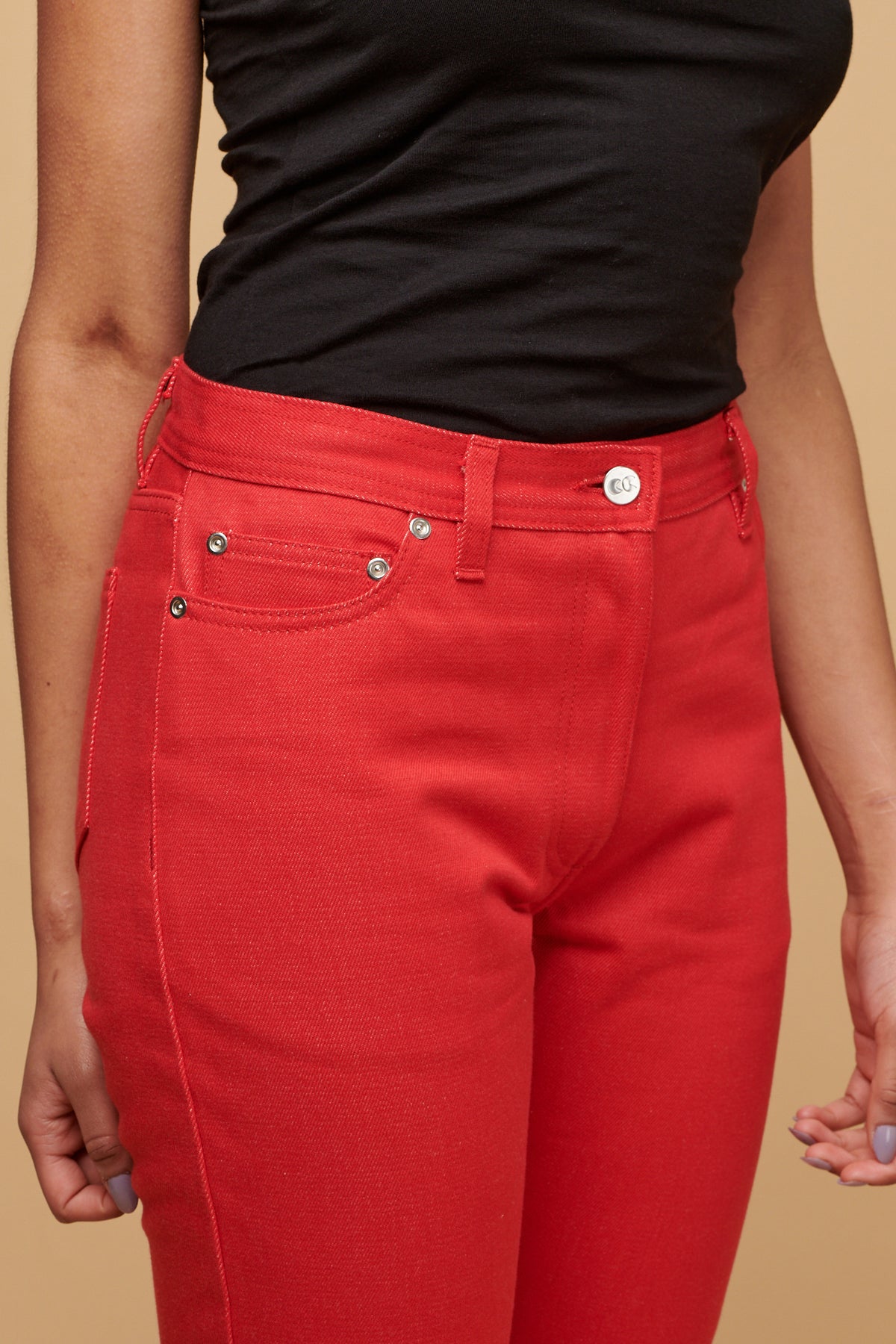 Close up of the front of female wearing Gloria jeans in poppy, silver rivets and CC logo button fastening, belt loops