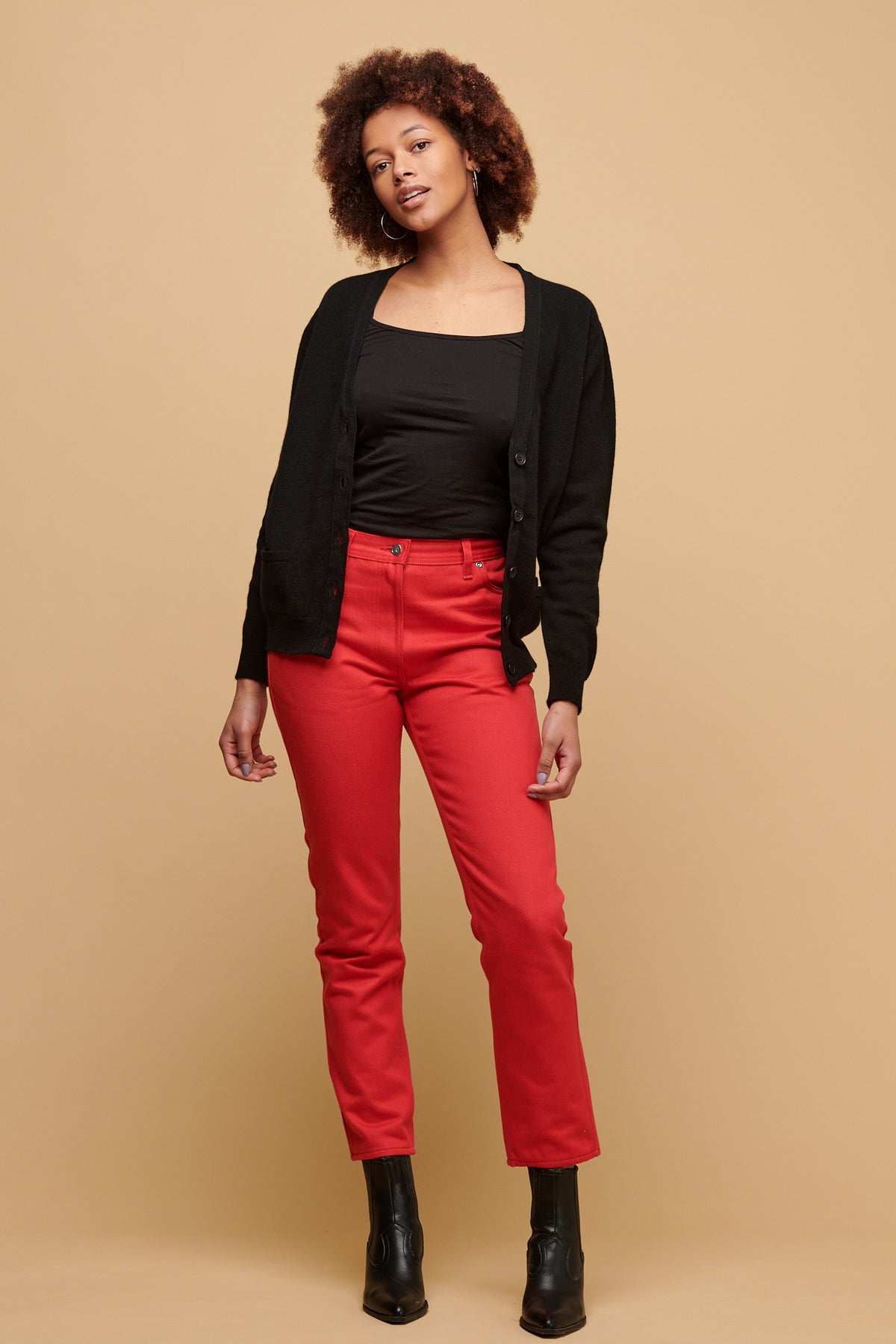 Front of female of colour wearing Gloria Jean in poppy paired with black camisole tucked in with unbuttoned v neck cardigan in black
