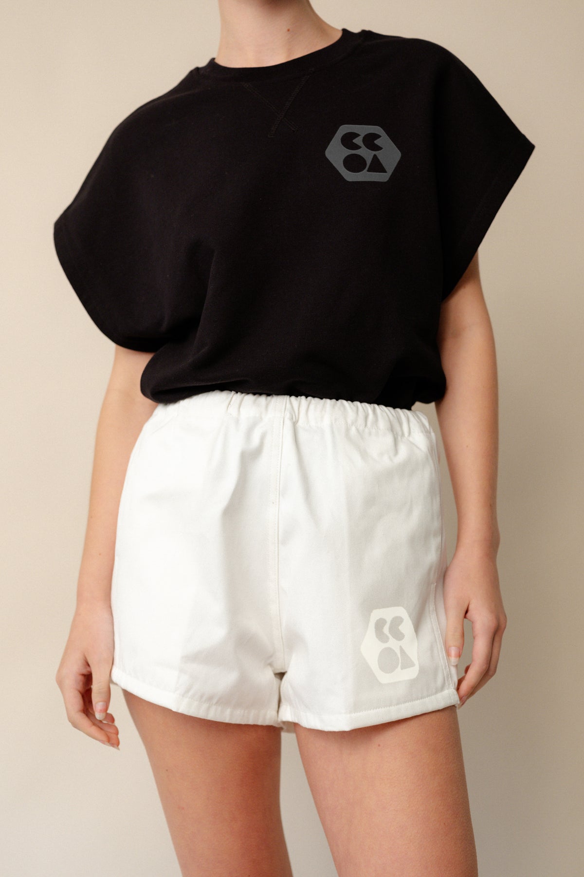 Neck to thigh shot of white female wearing heavyweight sports short plastic free in white