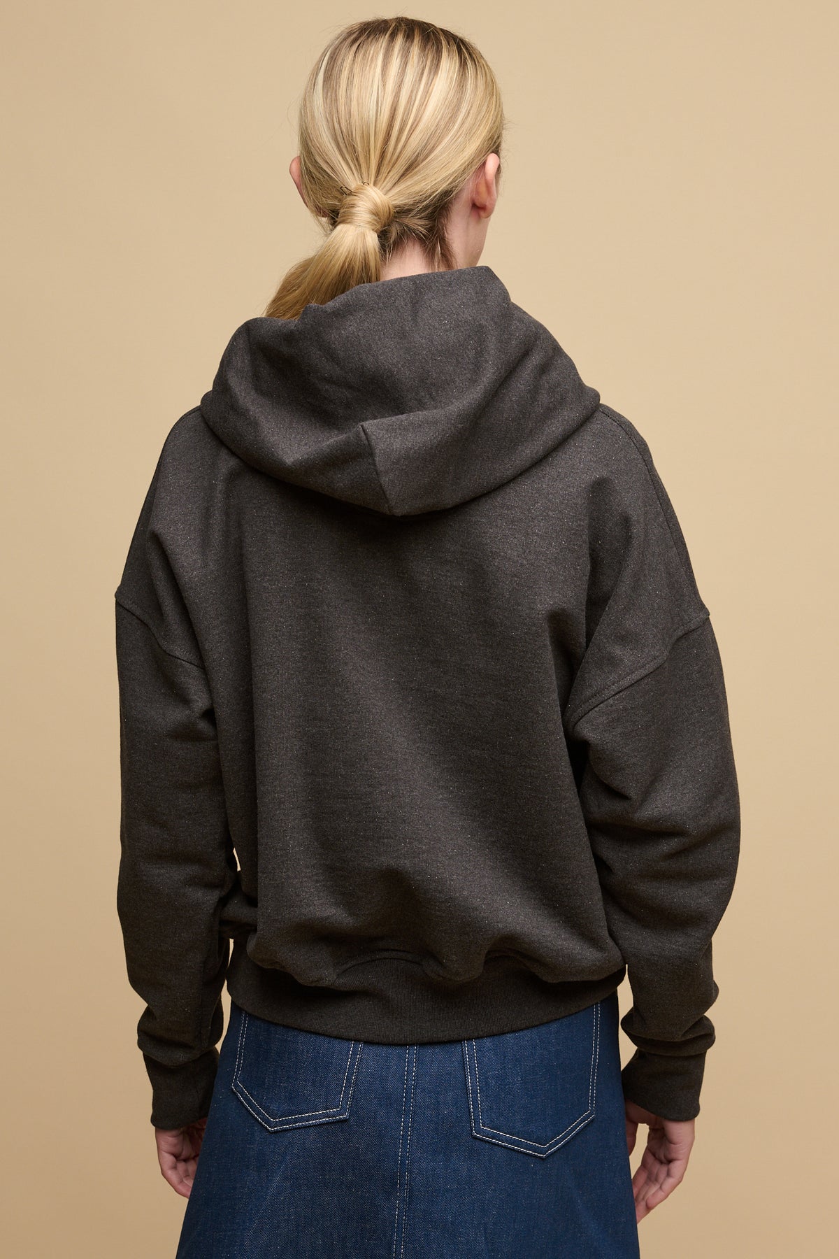 
            The back of blonde female wearing heritage hooded sweatshirt in charcoal