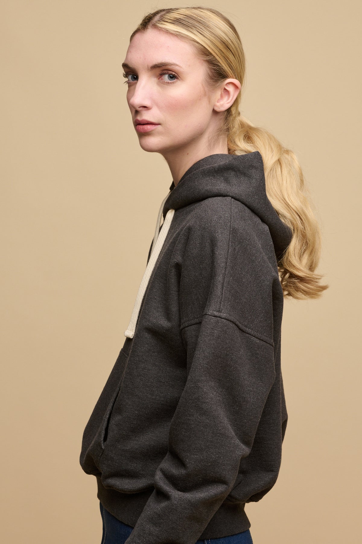 The side of female wearing heritage hooded sweatshirt in charcoal