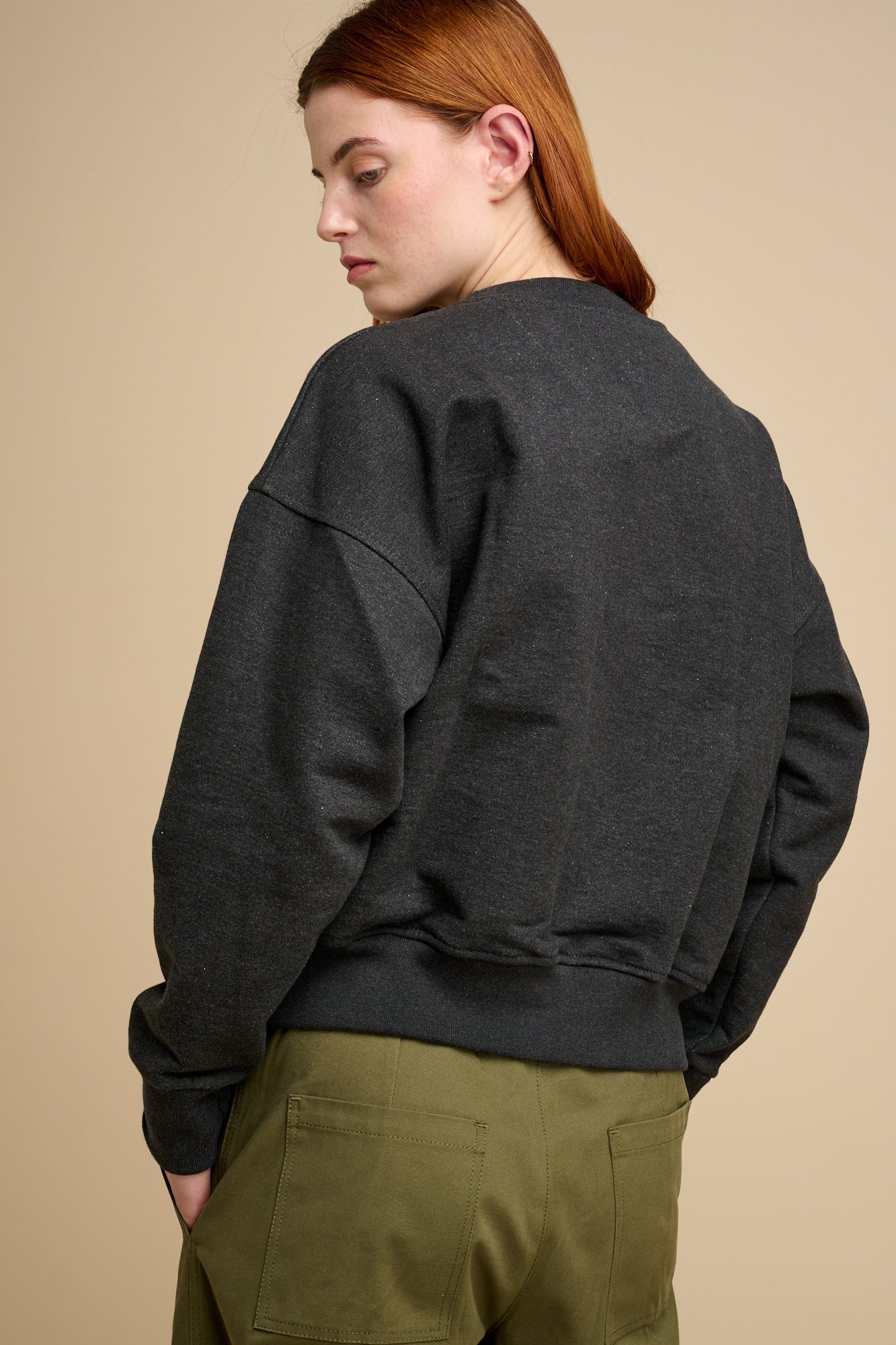 Woman wearing charcoal heavyweight sweatshirt  with olive trousers
