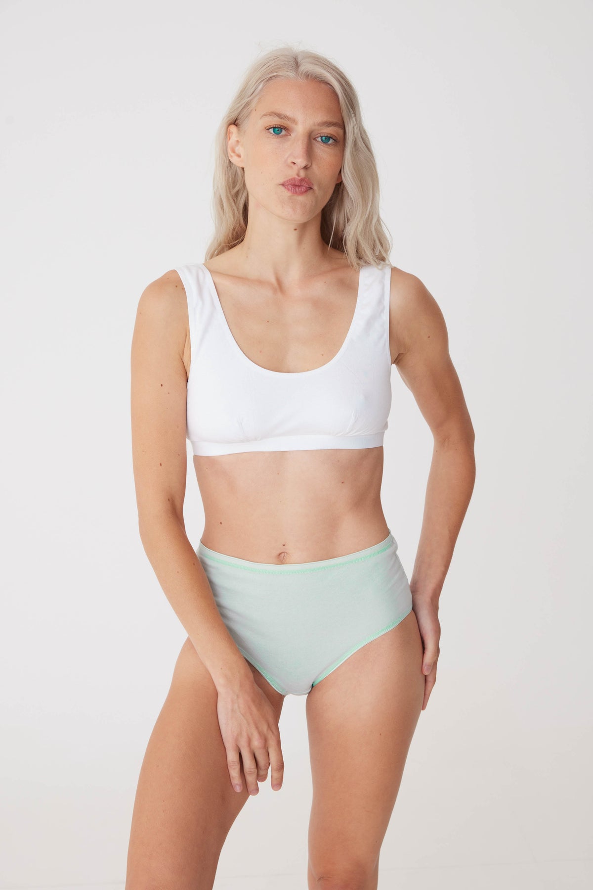 blonde, white female wearing high rise brief in sage paired with white soft jersey bra