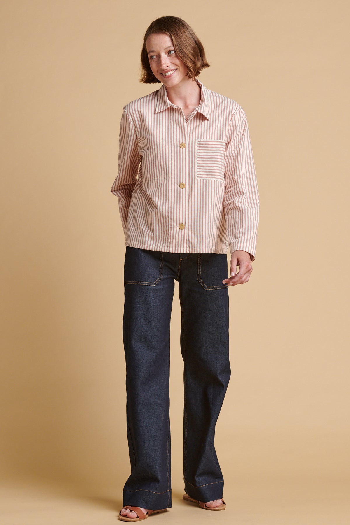 Woman wearing indigo jeans and stripy shirt.