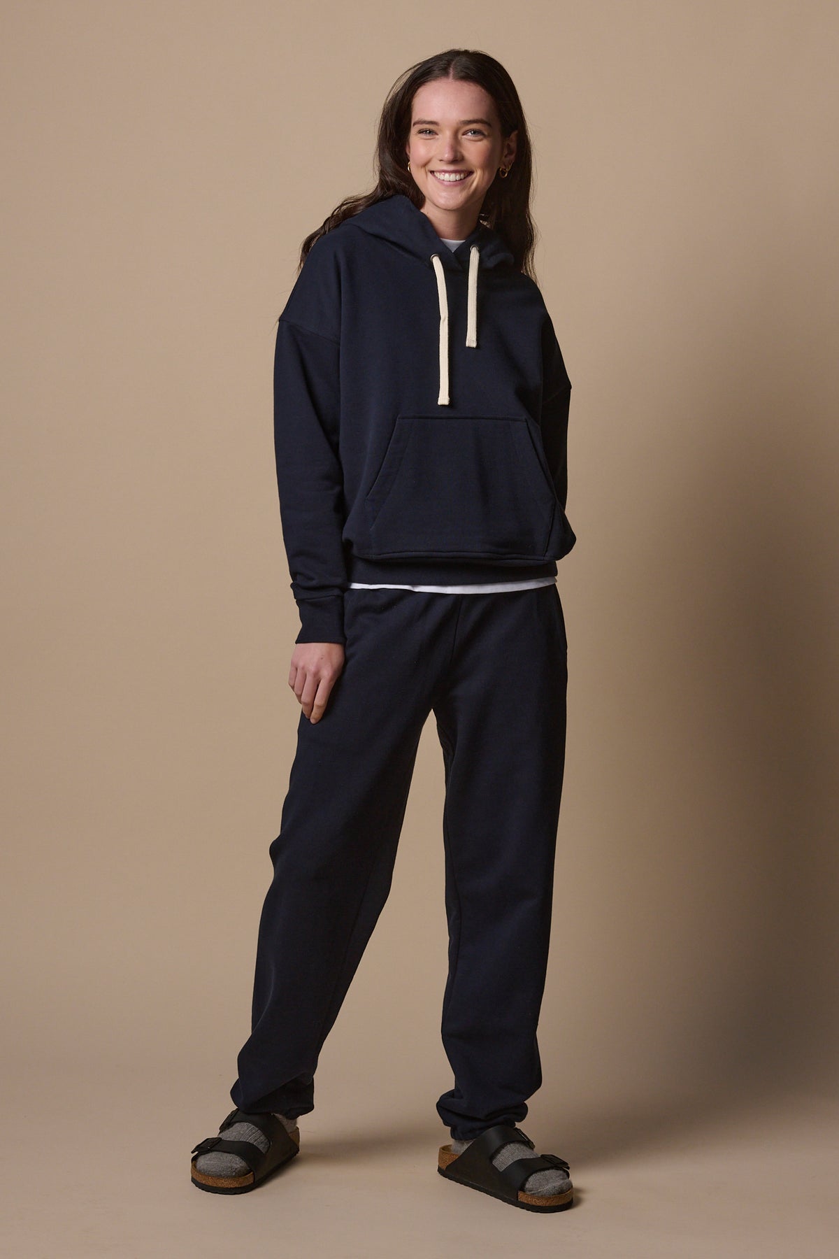 
            Full body image of female wearing hooded sweatshirt in navy with matching navy sweatpants