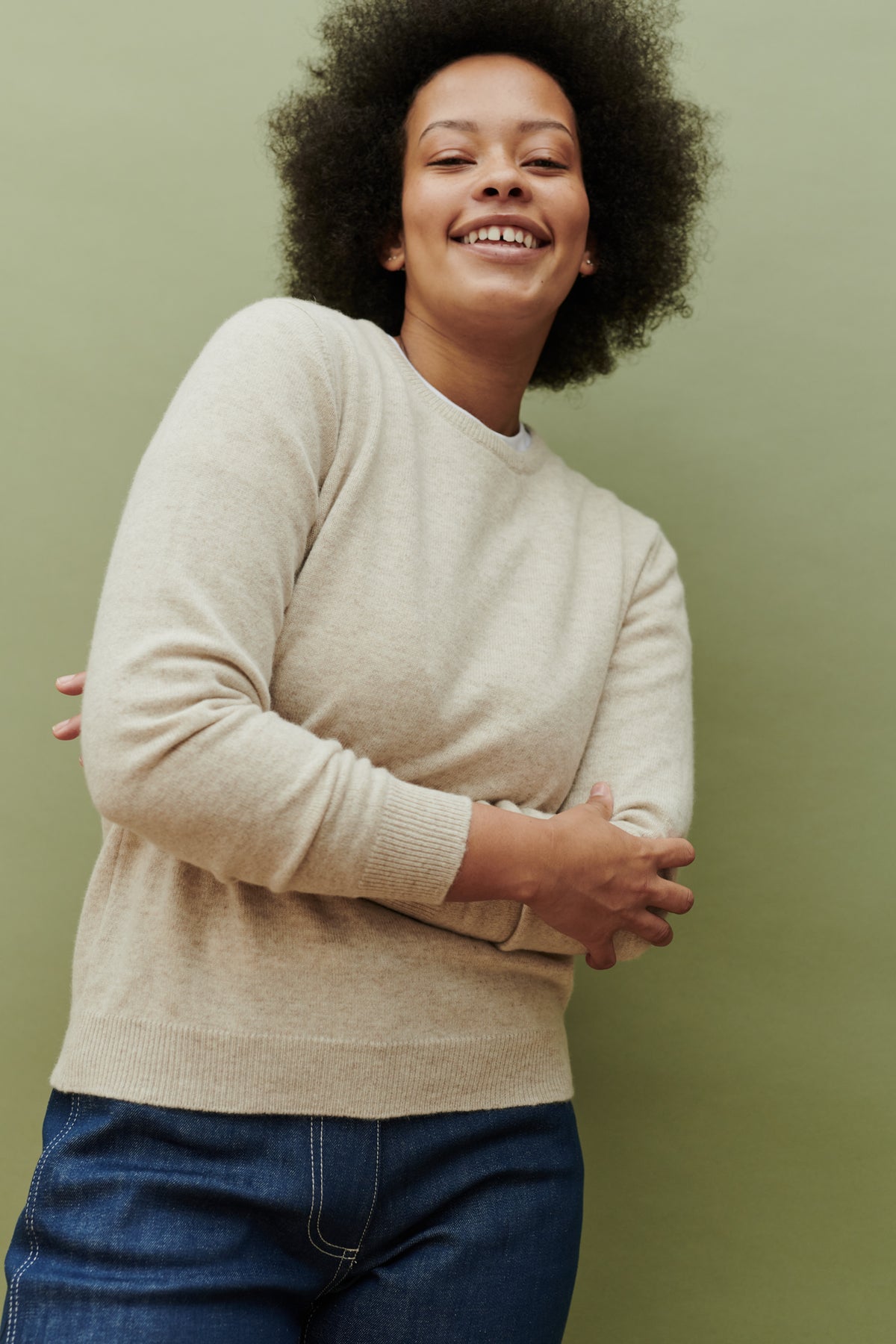 Thigh up image of female wearing lambswool crew neck jumper in linen