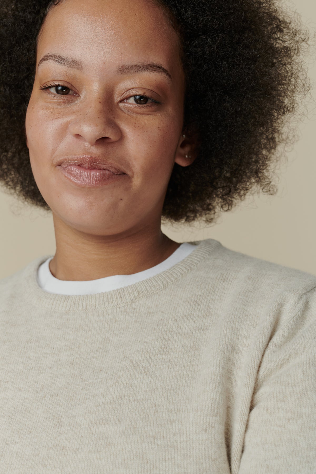 Portrait image of female wearing lambswool crew neck jumper in linen