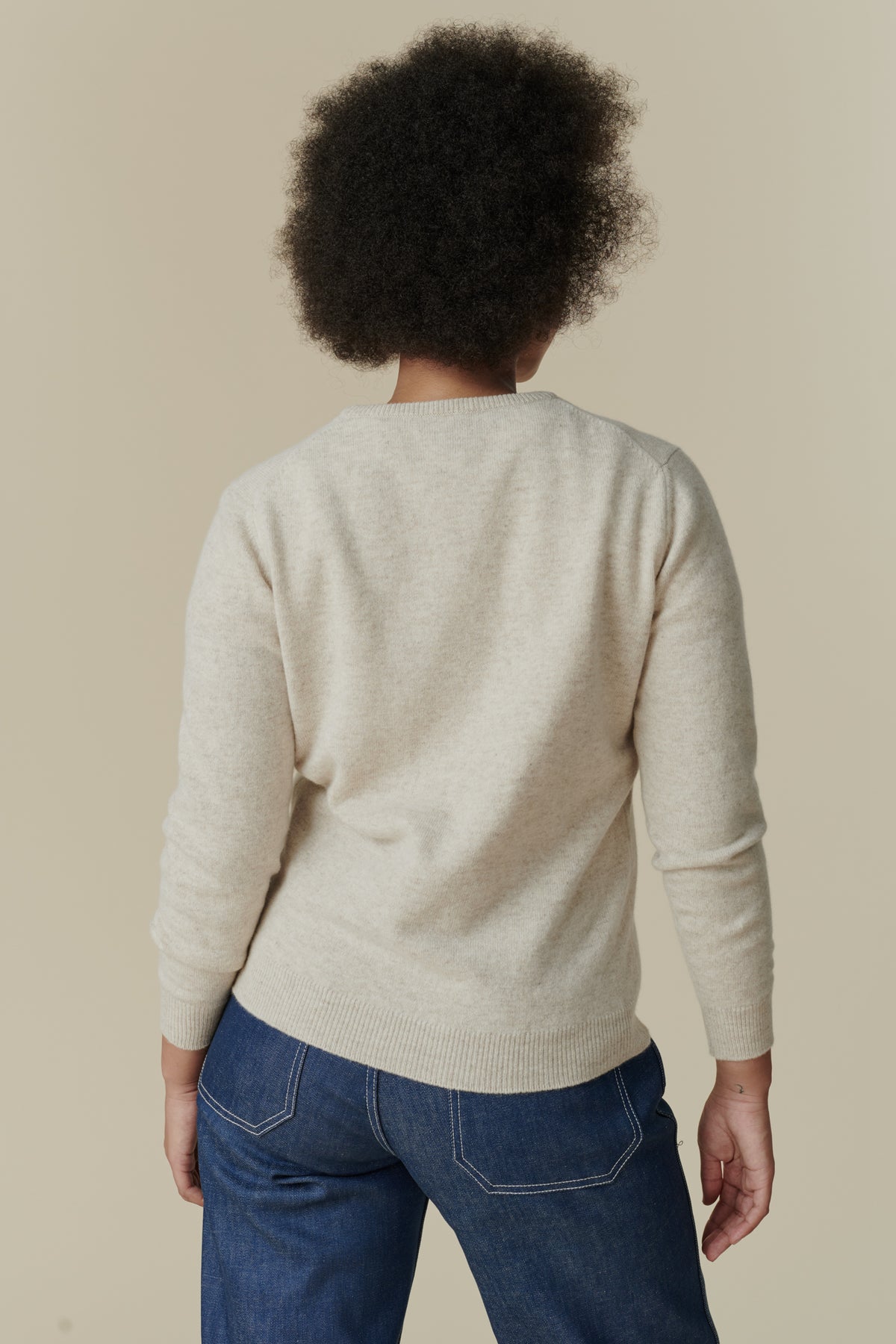 
            Thigh up image of back of female wearing lambswool crew neck jumper in linen
