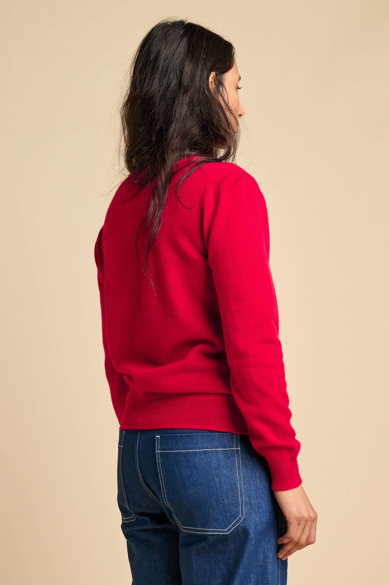 The back of a woman wearing lambswool crew neck jumper in red.