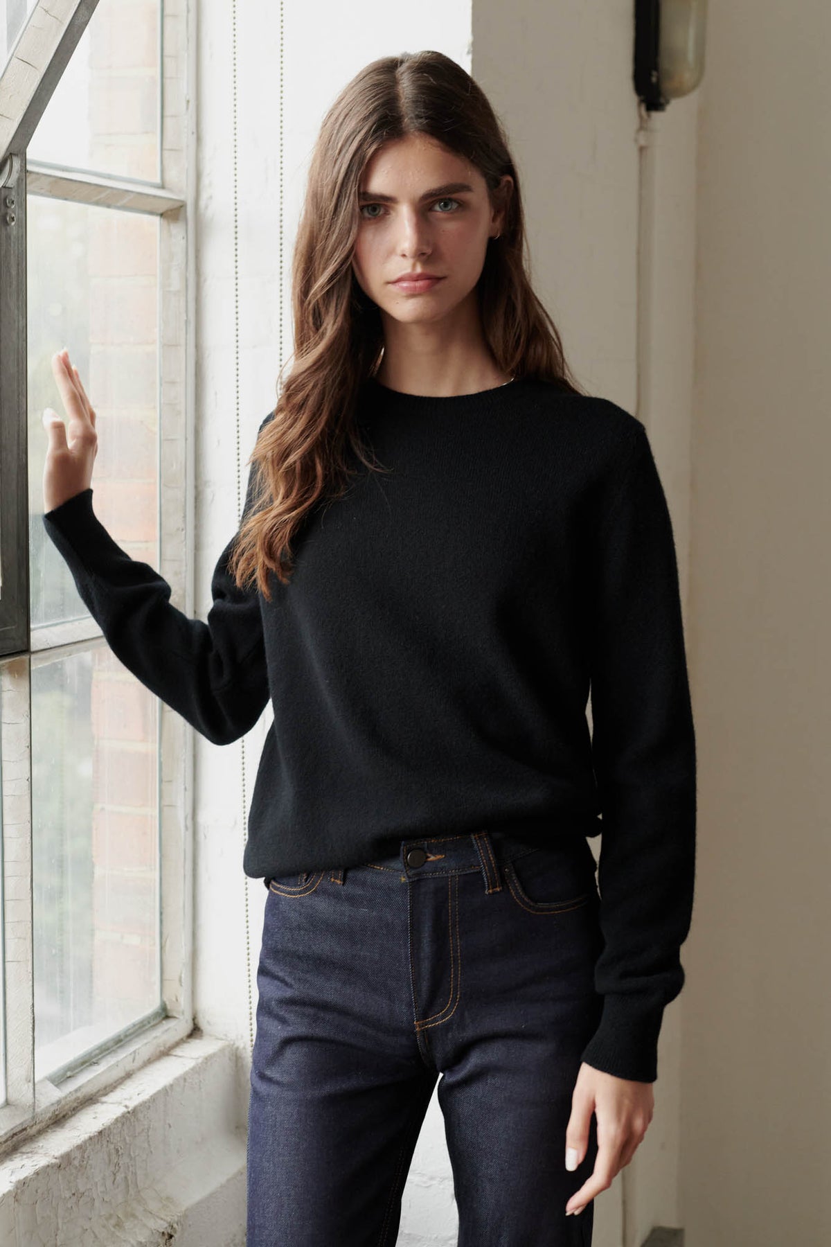 Brunette female wearing lambswool crew neck in black