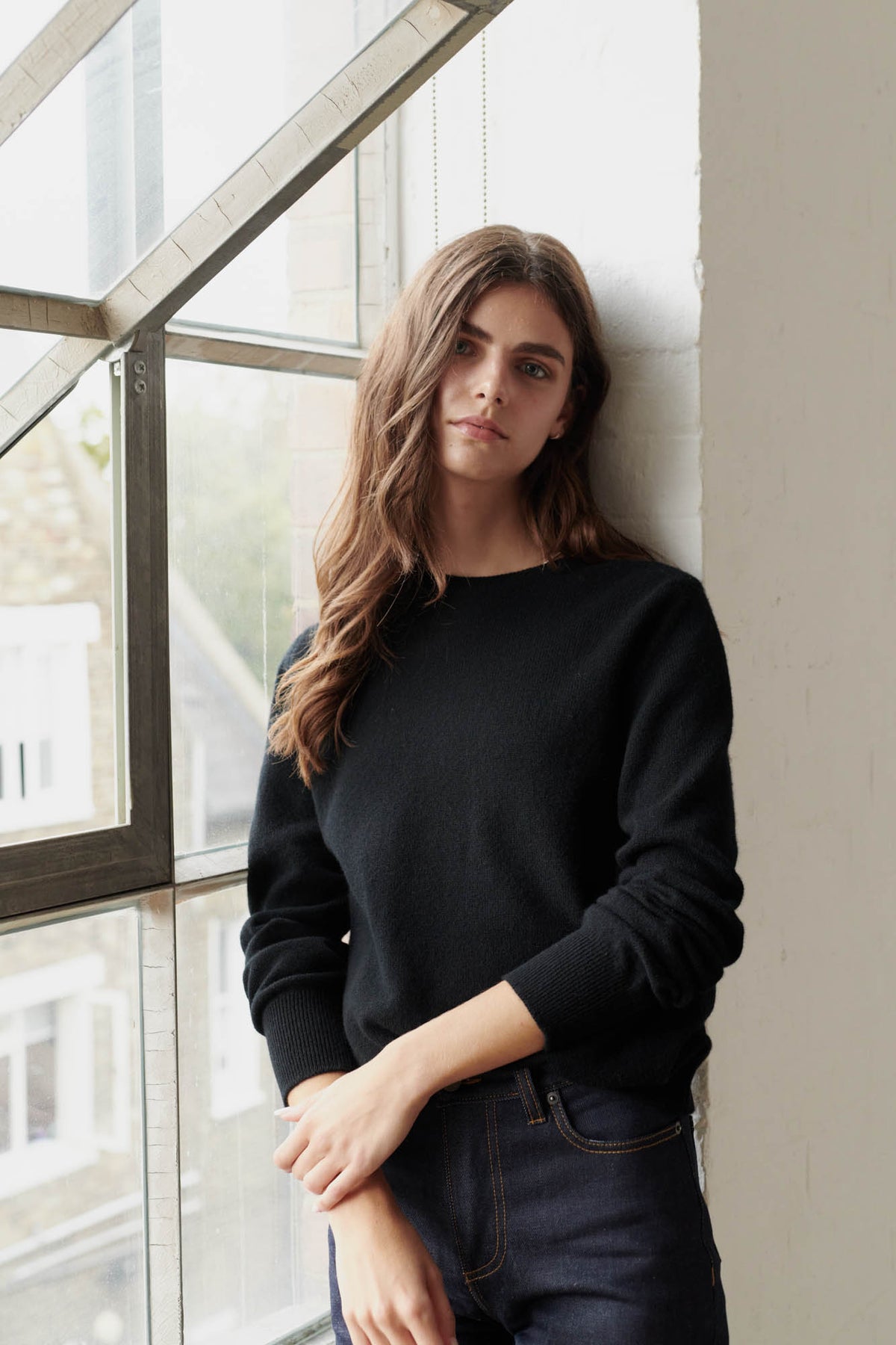 
            Brunette female wearing lambswool crew neck in black