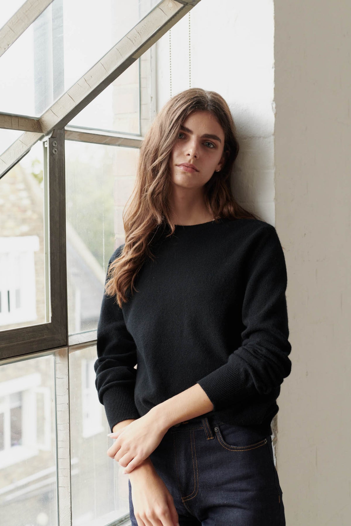Brunette female wearing lambswool crew neck in black