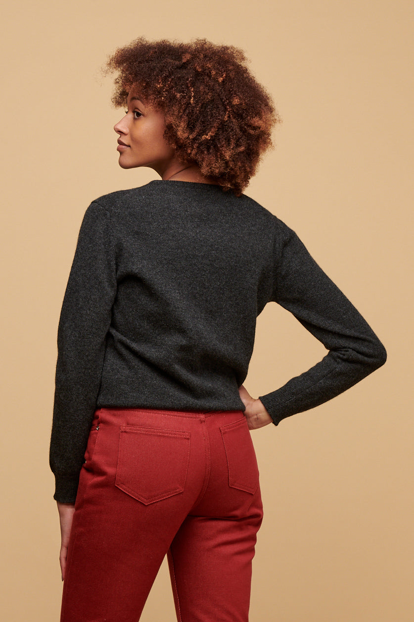 Thigh up image of the back of female wearing lambswool crew neck jumper in charcoal paired with Gloria jeans in burgundy