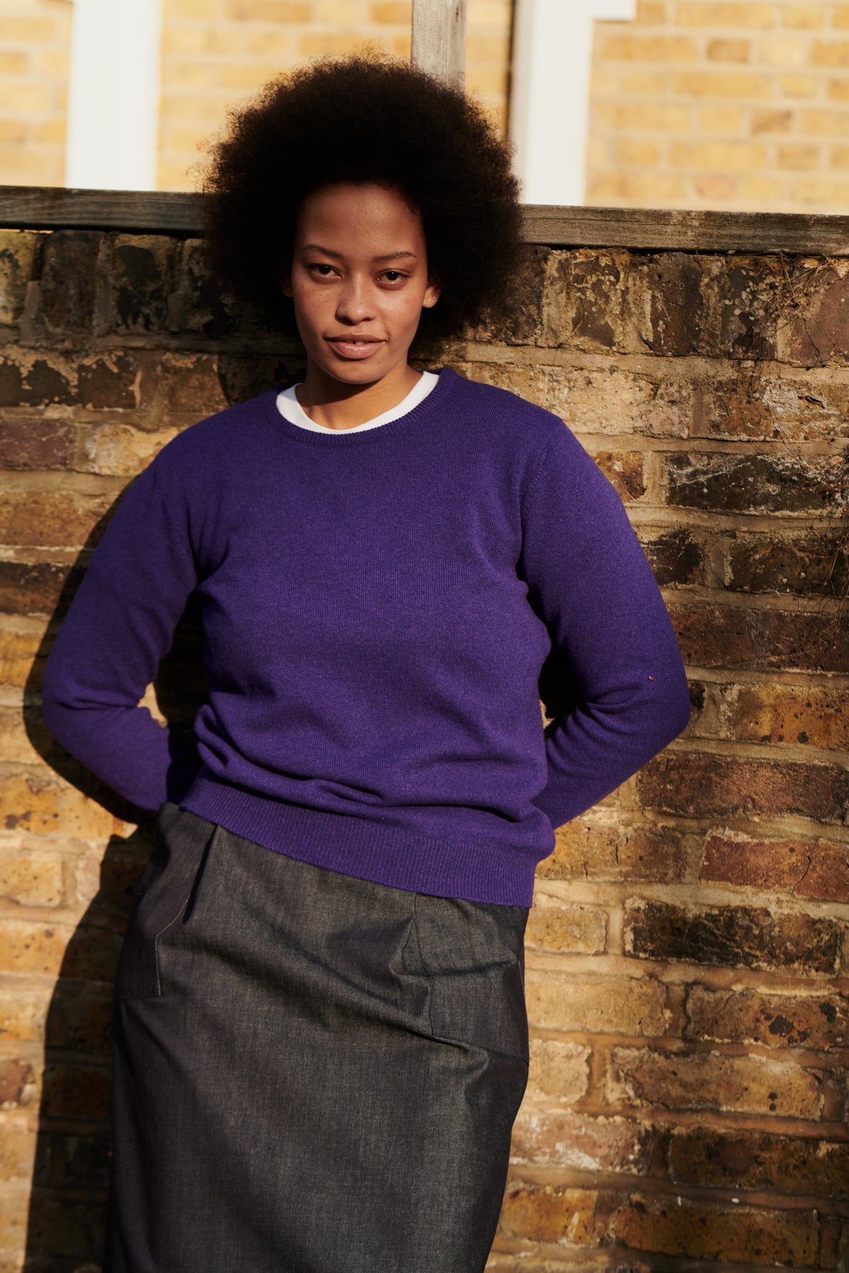 
            Front of female wearing lambswool crew neck in dark purple