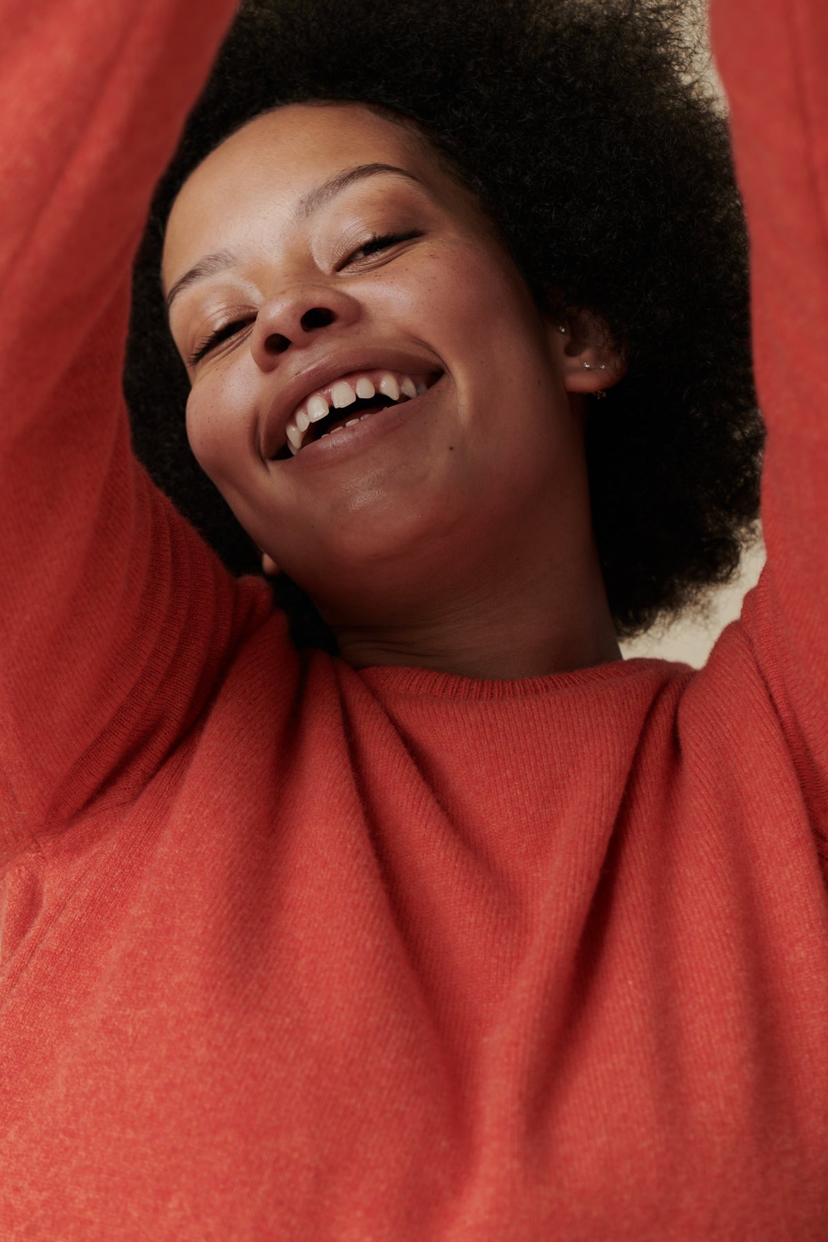 
            Portrait of female wearing lambswool crew neck in flame red