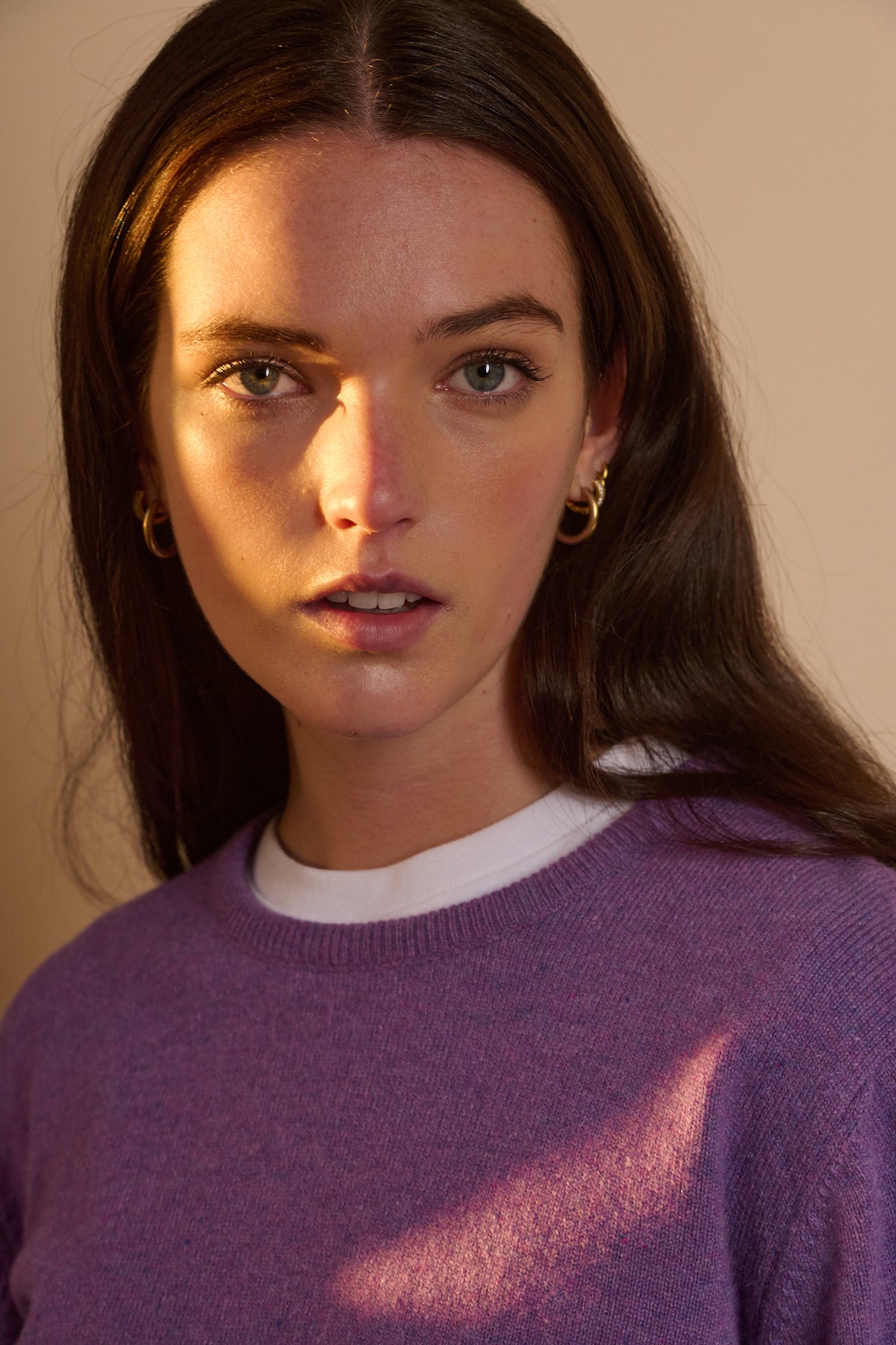 Portrait of female wearing lambswool crew neck in thistle purple with white t shirt layered underneath