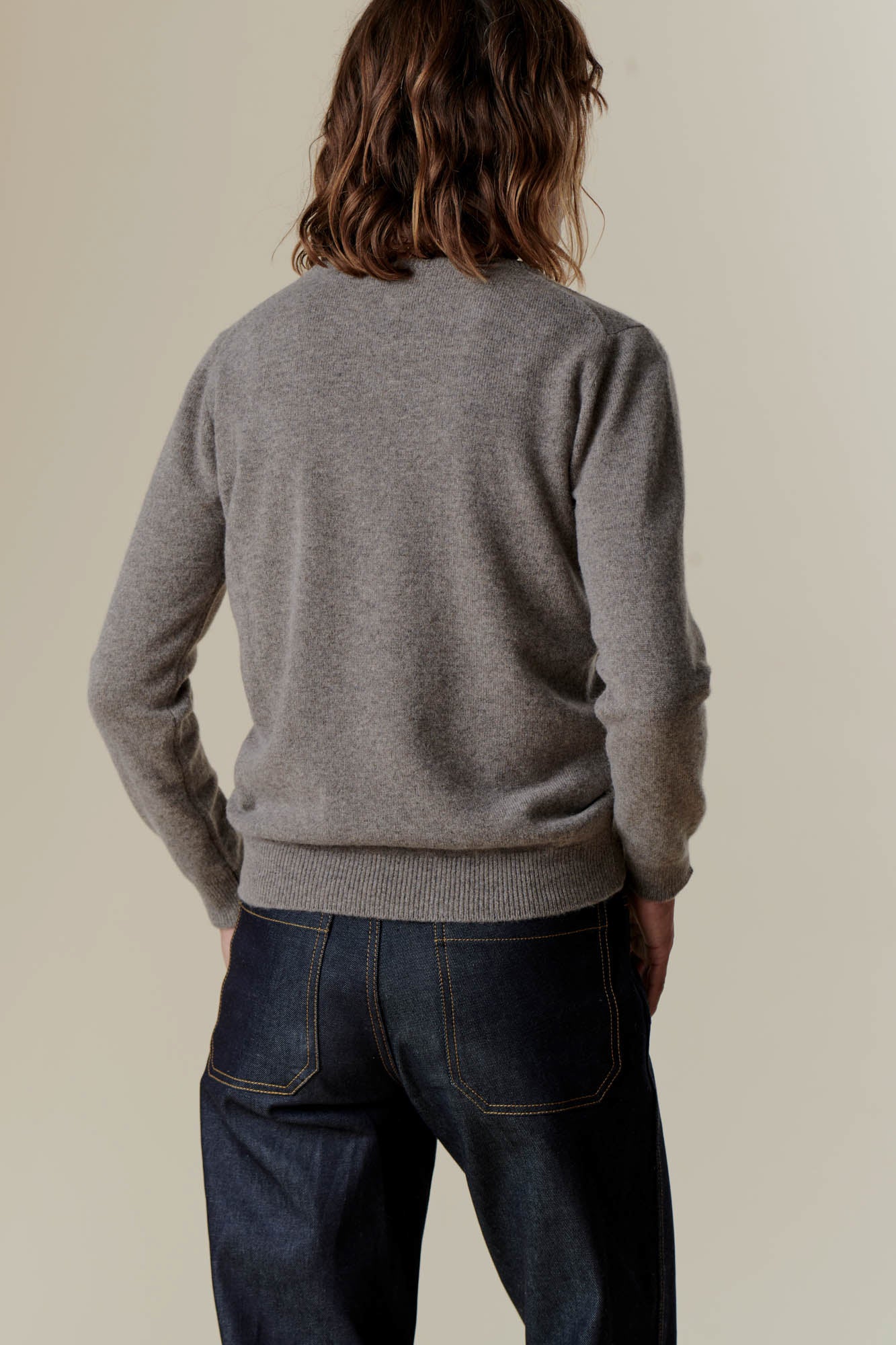 Brunette female wearing lambswool crew neck in truffle