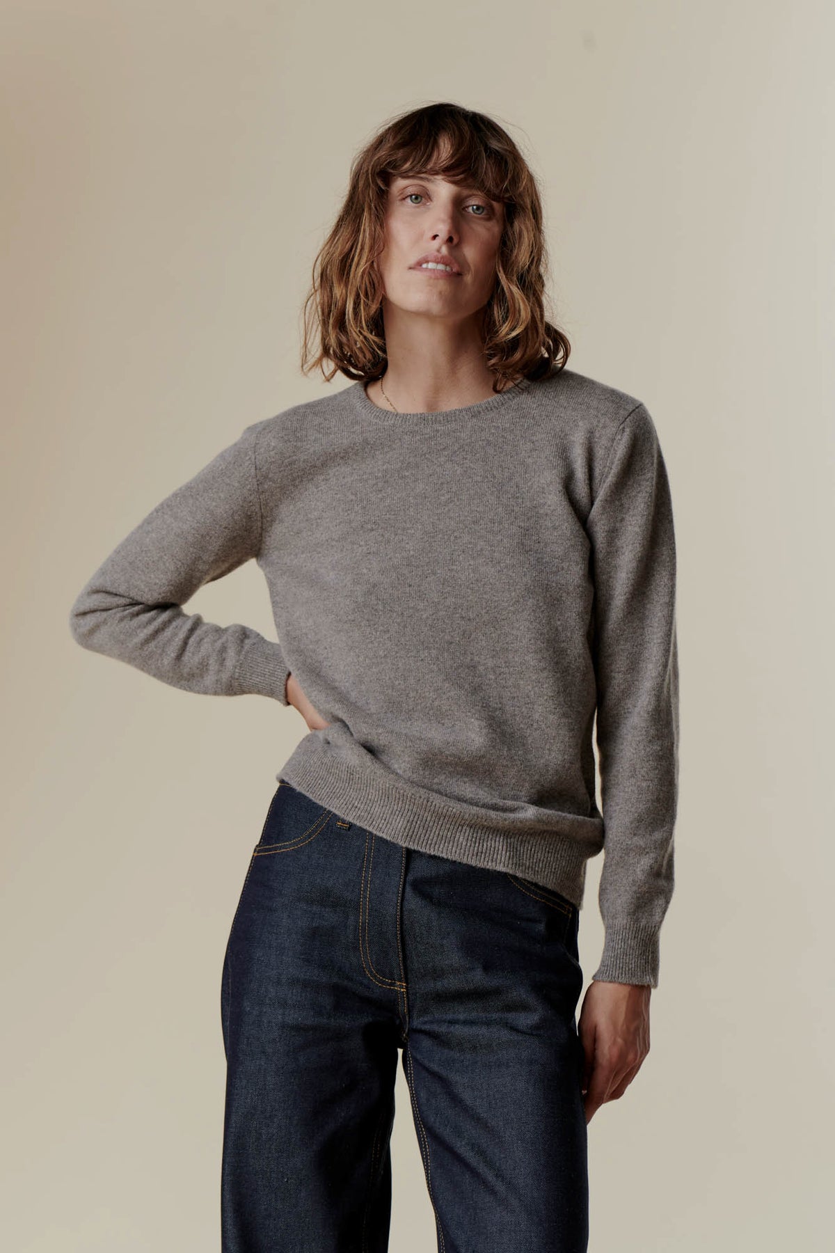 
            Female wearing lambswool crew neck in truffle