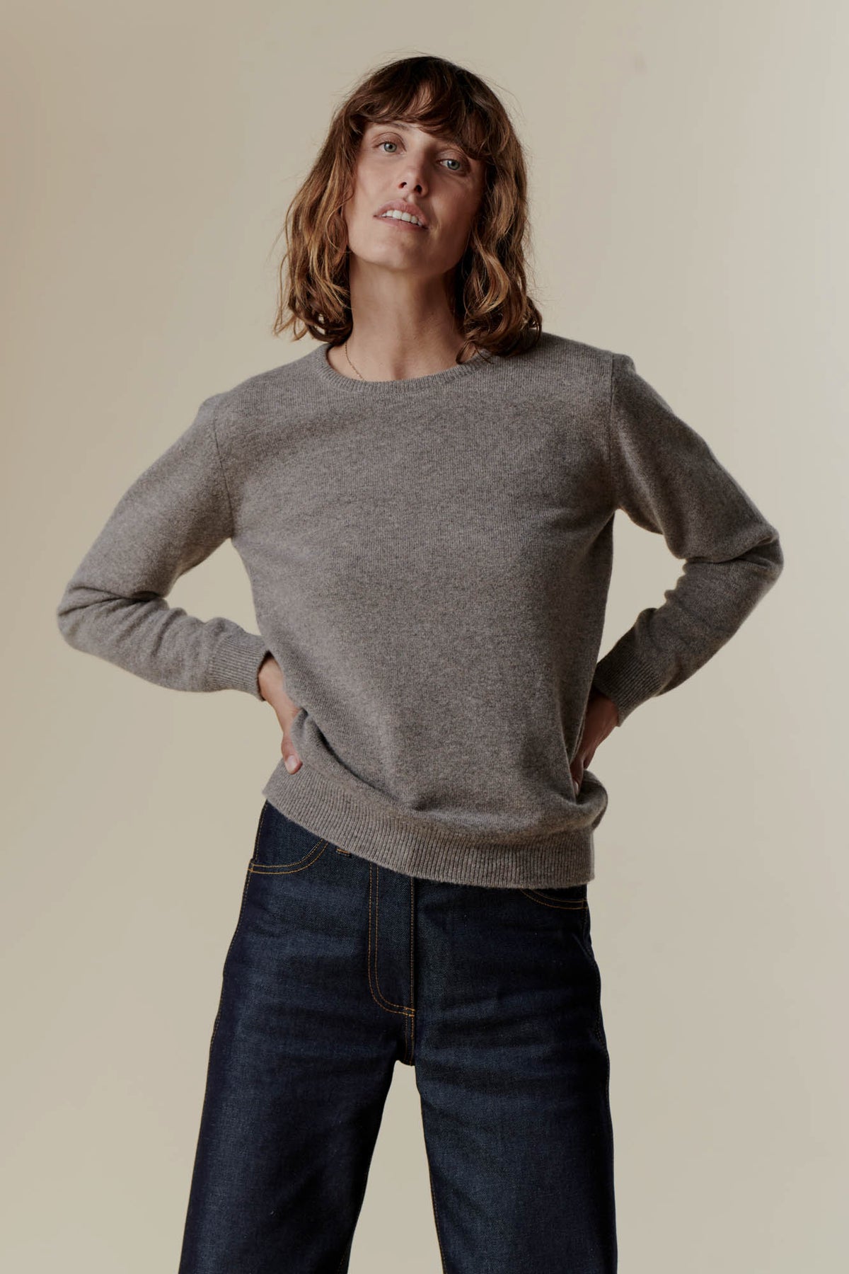 Brunette female wearing lambswool crew neck in truffle