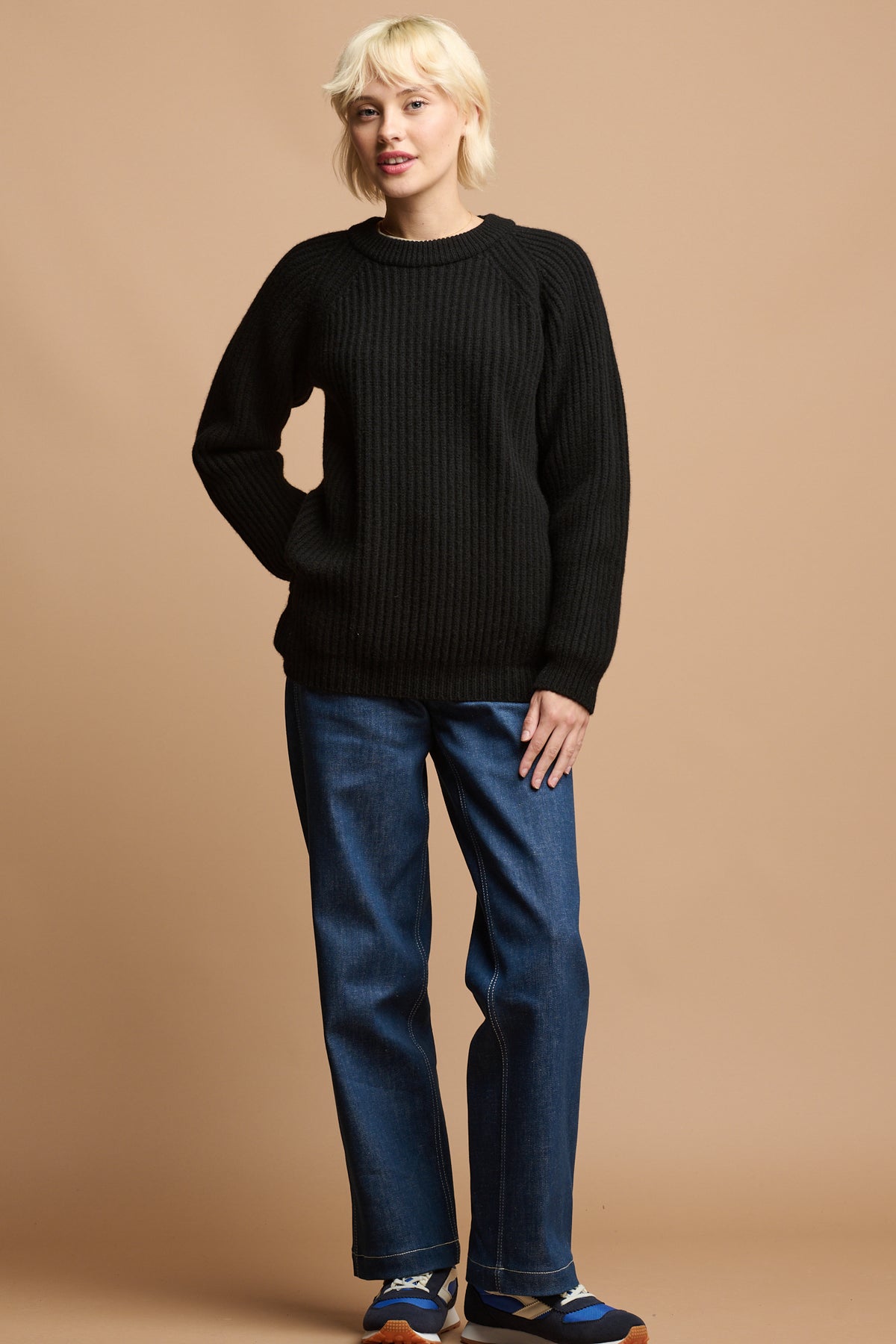 
            female with blonde hair wearing lambswool fisherman ribbed jumper in black paired with women&#39;s work jeans in blue