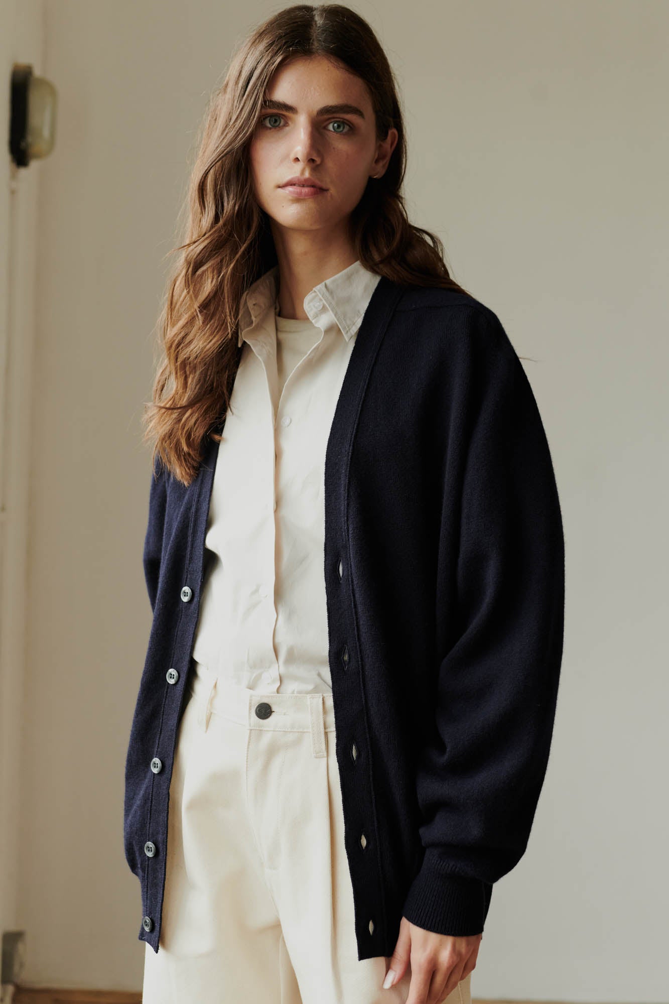 Brunette female wearing unbuttoned lambswool v neck cardigan