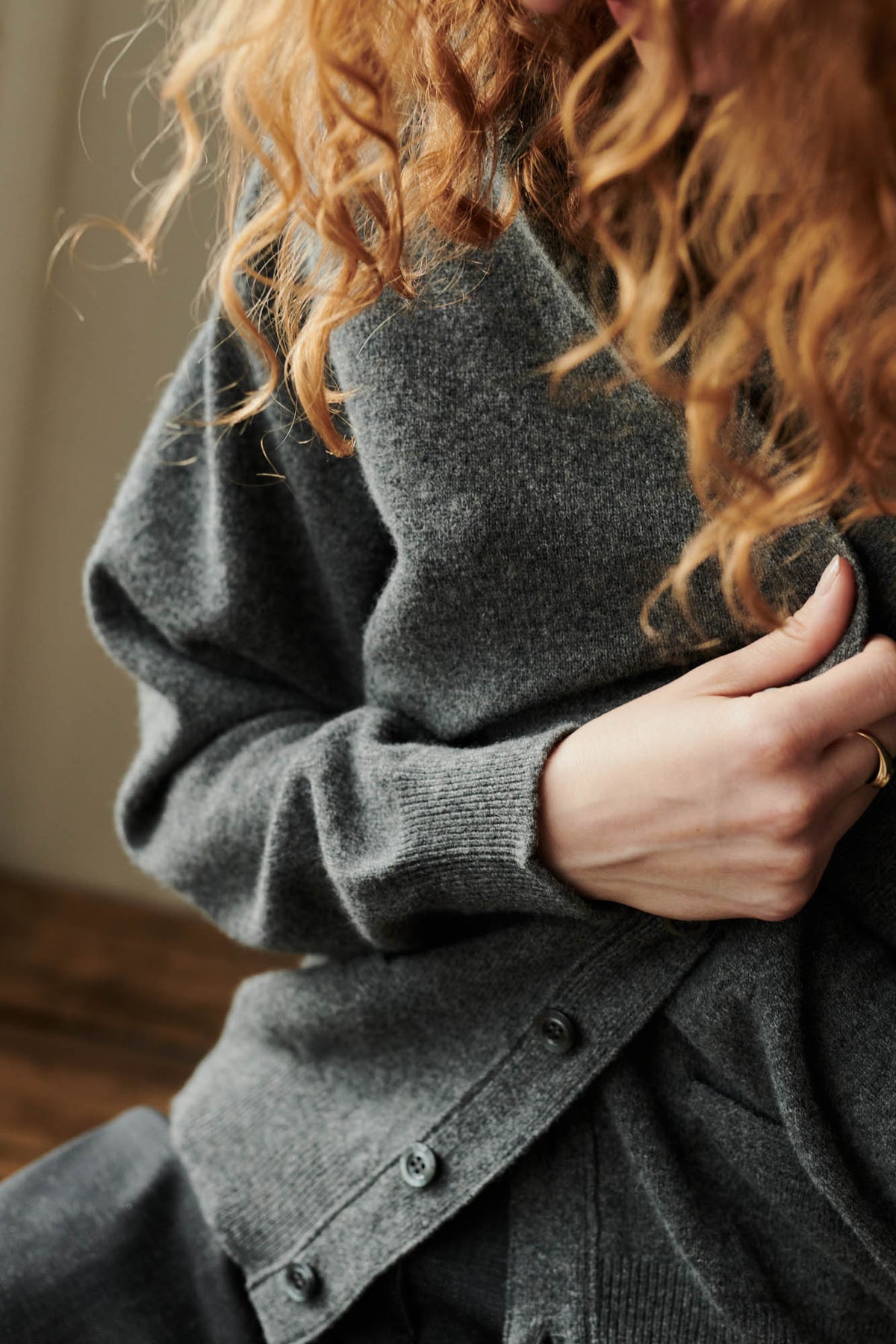 
            rib cuff and button detail of charcoal cardigan