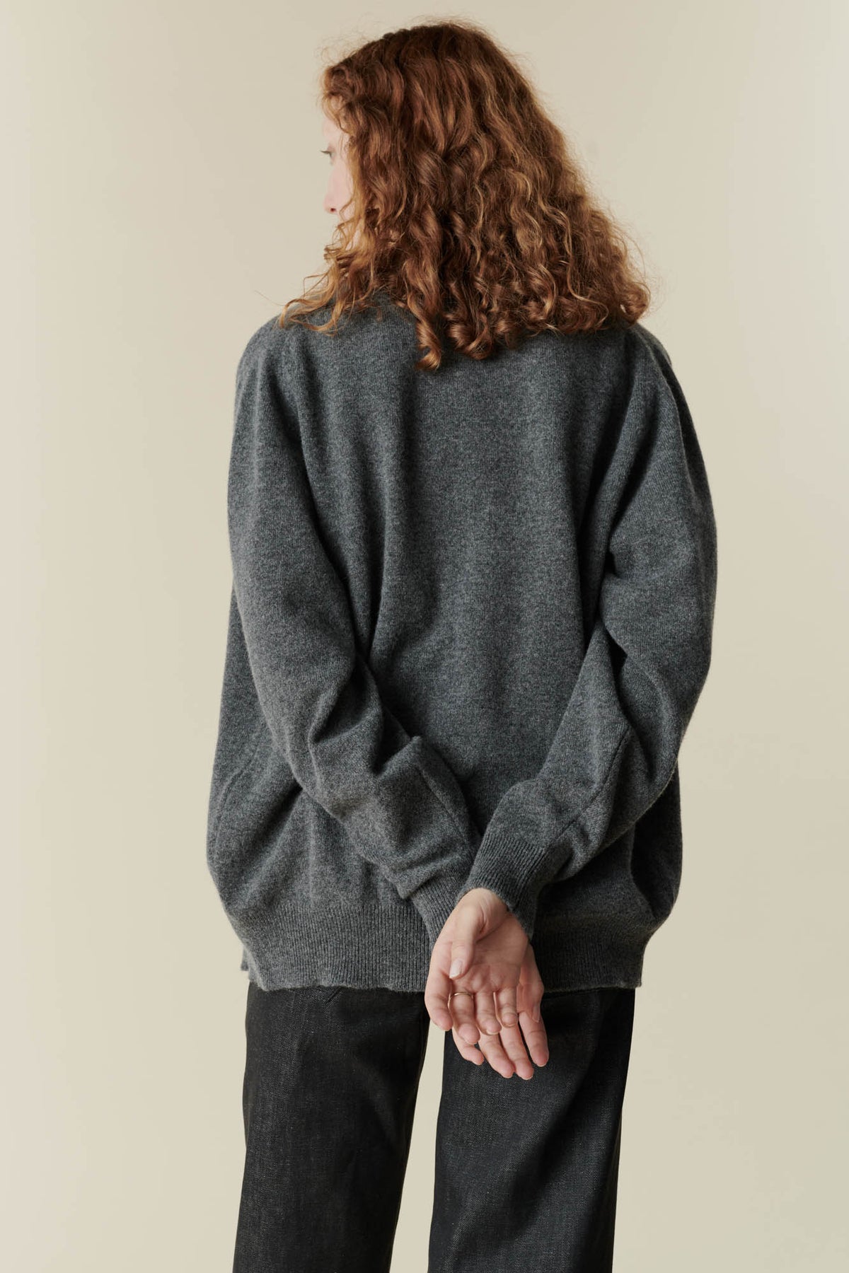 Image of back of female wearing v neck cardigan in charcoal