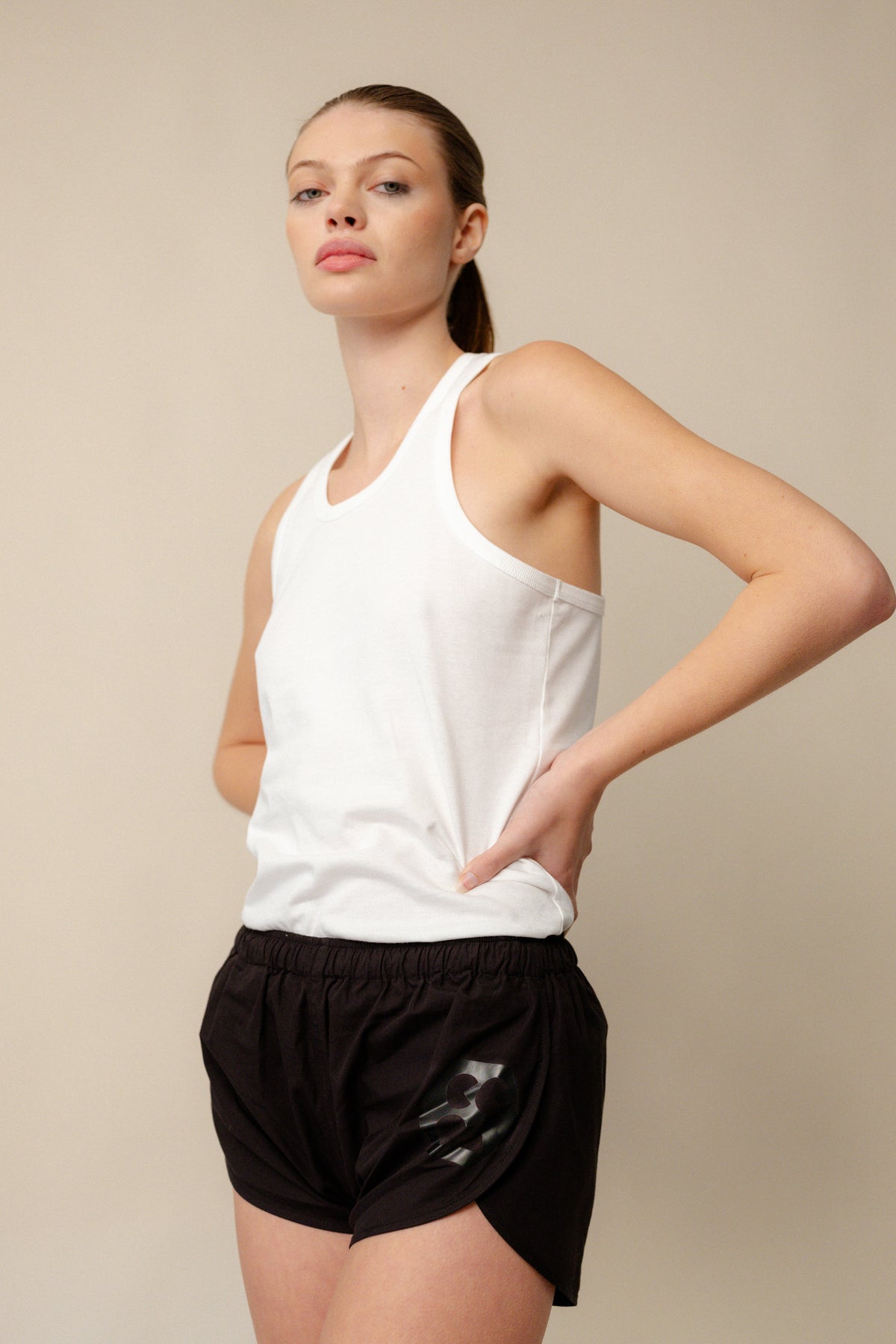 Image of white female thigh up wearing lightweight running short plastic free in black with CCOA logo